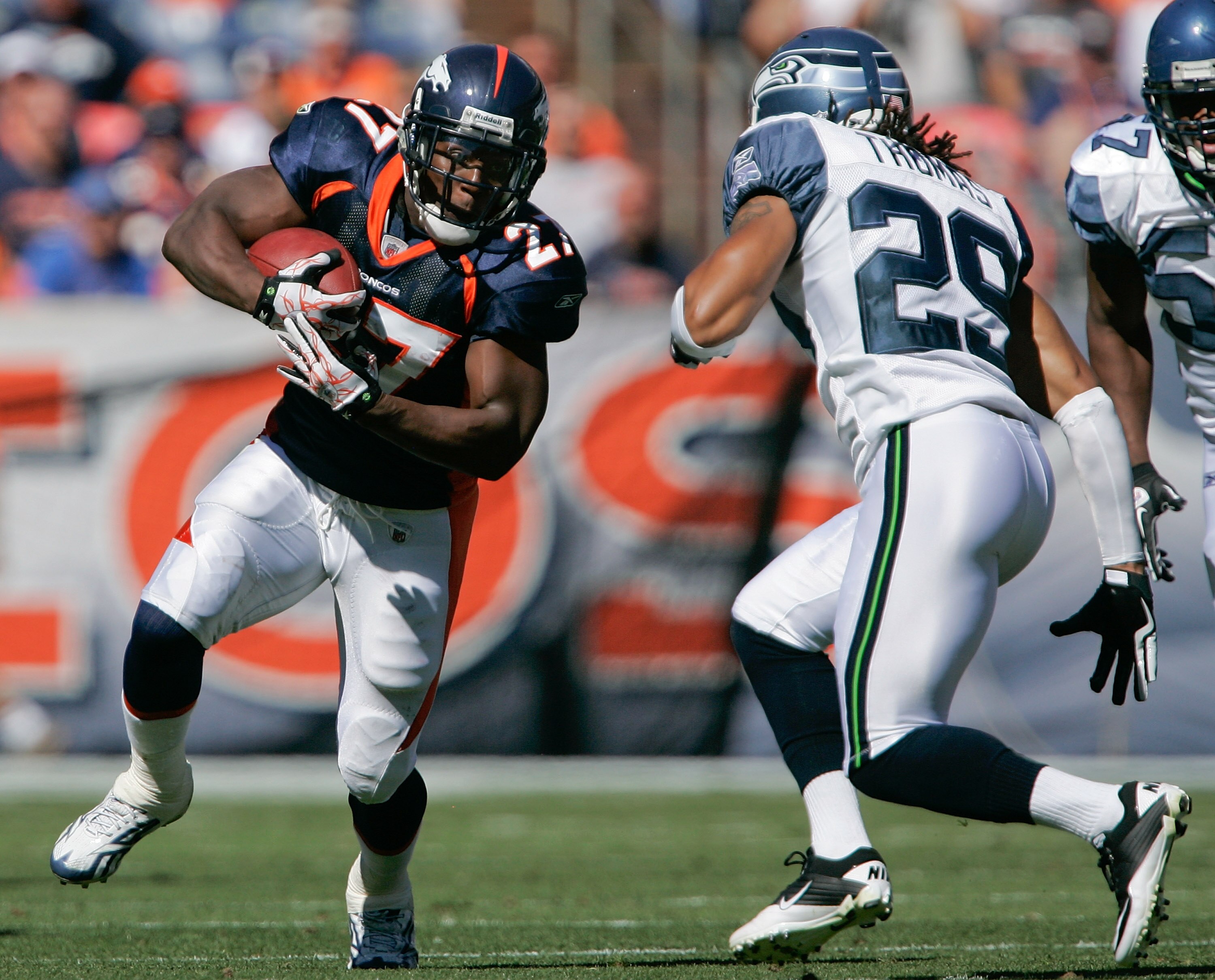 DENVER - SEPTEMBER 19:  Running back Knowshon Moreno #27 of the Denver Broncos runs through a hole as safety Earl Thomas #29 of the Seattle Seahawks looks to make a tackle during NFL action at INVESCO Field at Mile High on September 19, 2010 in Denver, Co