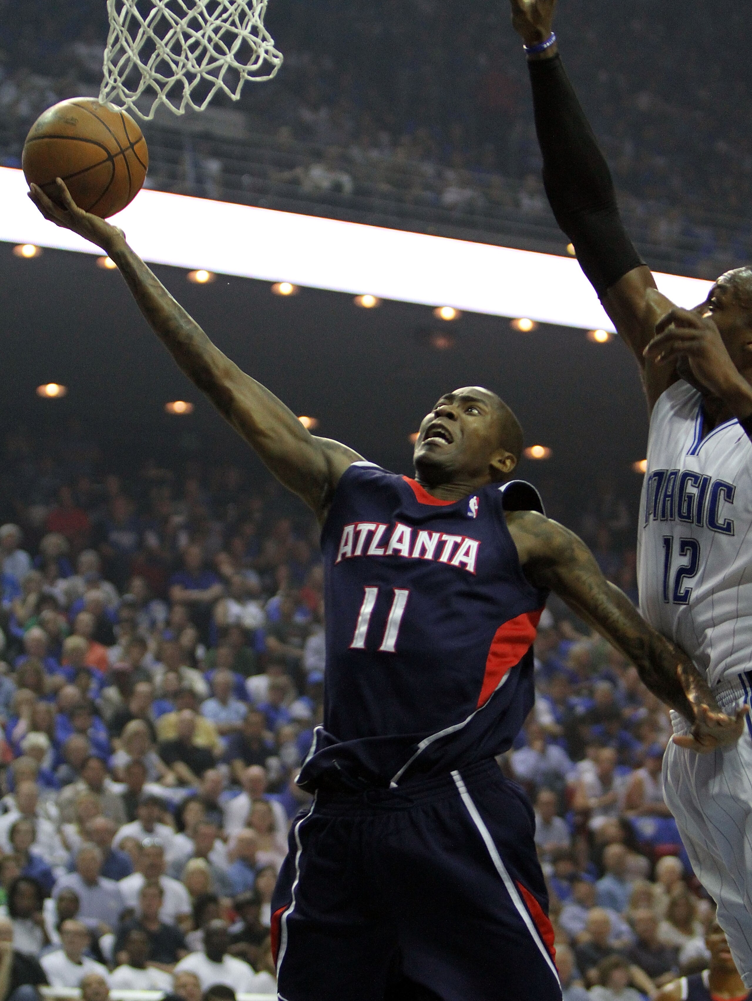 ORLANDO, FL - MAY 04:  Jamal Crawford #11 of the Atlanta Hawks scores past Dwight Howard #12 of the Orlando Magic in Game One of the Eastern Conference Semifinals during the 2010 NBA Playoffs at Amway Arena on May 4, 2010 in Orlando, Florida. NOTE TO USER