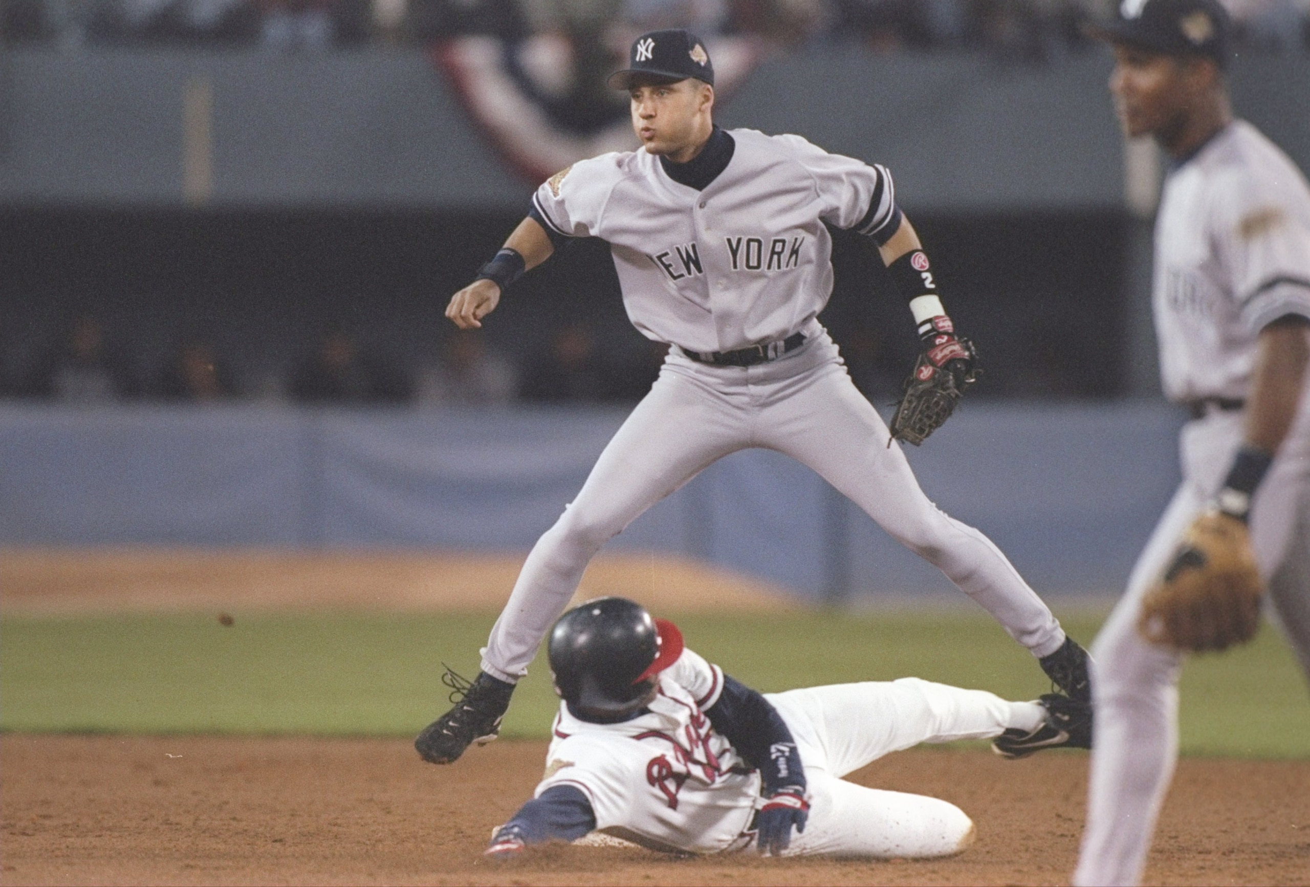 24 Oct 1996: Shortstop Derek Jeter of the New York Yankees jumps over a sliding first basemen Fred McGriff of the Atlanta Braves during game five of the World Series at Fulton County Stadium in Atlanta, Georgia. The Yankees won the game 1 - 0.