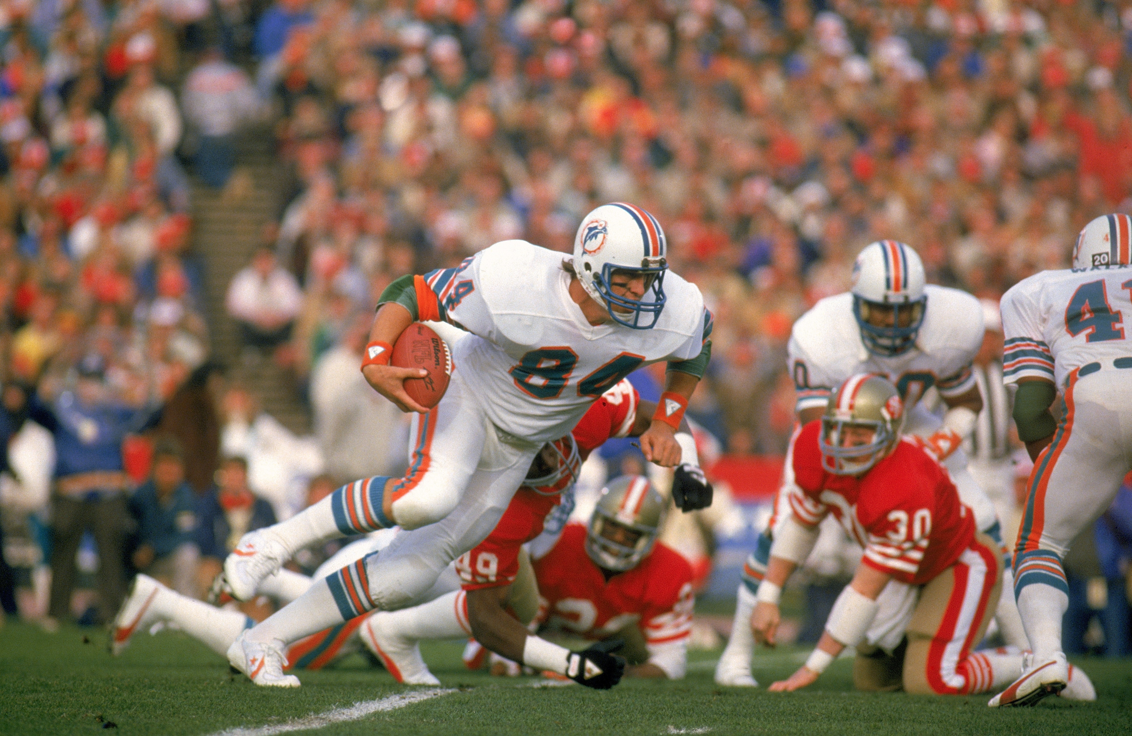 STANFORD, CA - JANUARY 20:  Bruce Hardy #84 of the Miami Dolphins runs with the ball during Super Bowl XIX against the San Francisco 49ers at Stanford Stadium on January 20, 1985 in Stanford, California.  The 49ers defeated the Dolphins 38-16.  (Photo by