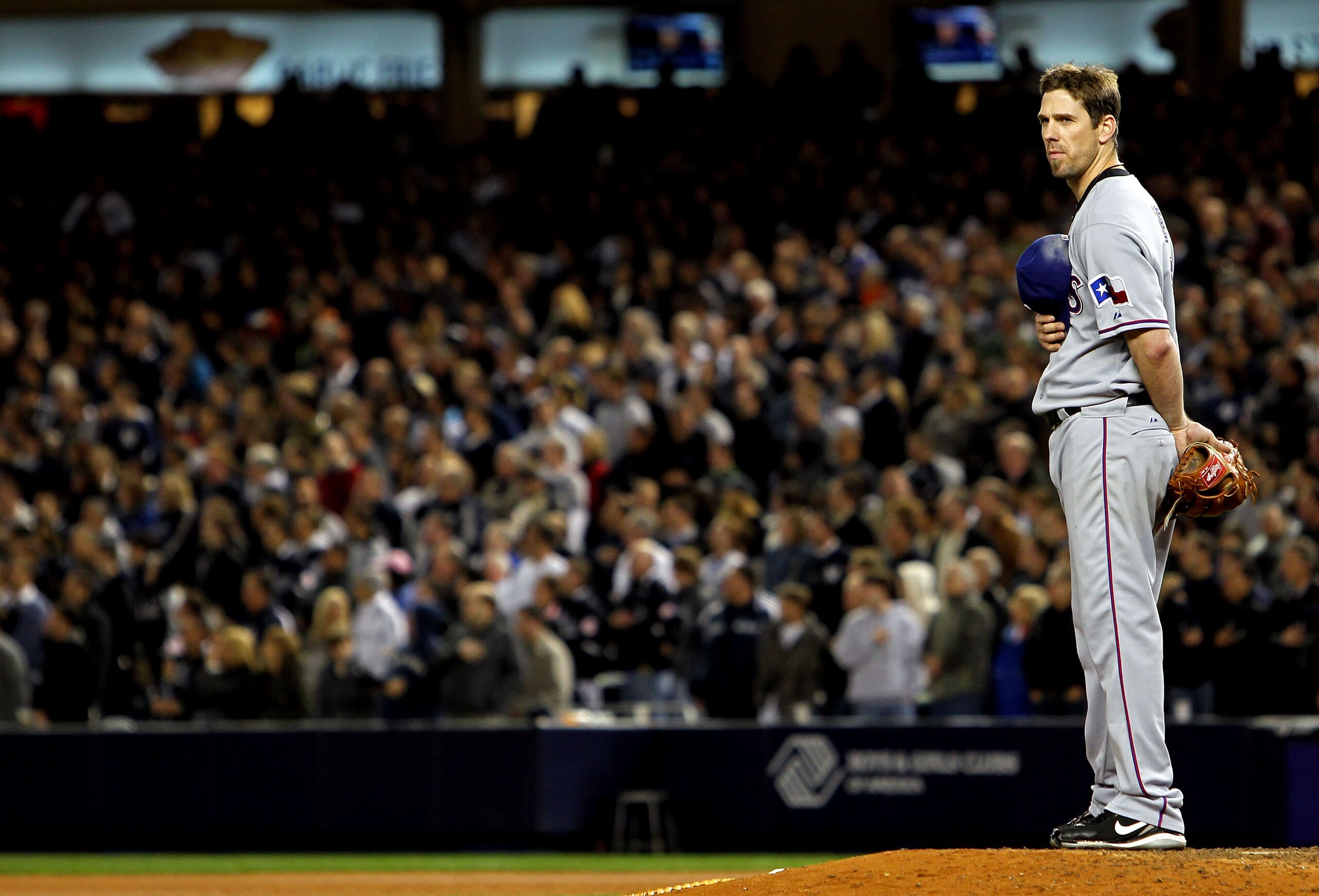 NEW YORK - OCTOBER 18:  Cliff Lee #33 of the Texas Rangers stands on the mound for the performance of 'Gob Bless America' against the New York Yankees in Game Three of the ALCS during the 2010 MLB Playoffs at Yankee Stadium on October 18, 2010 in New York