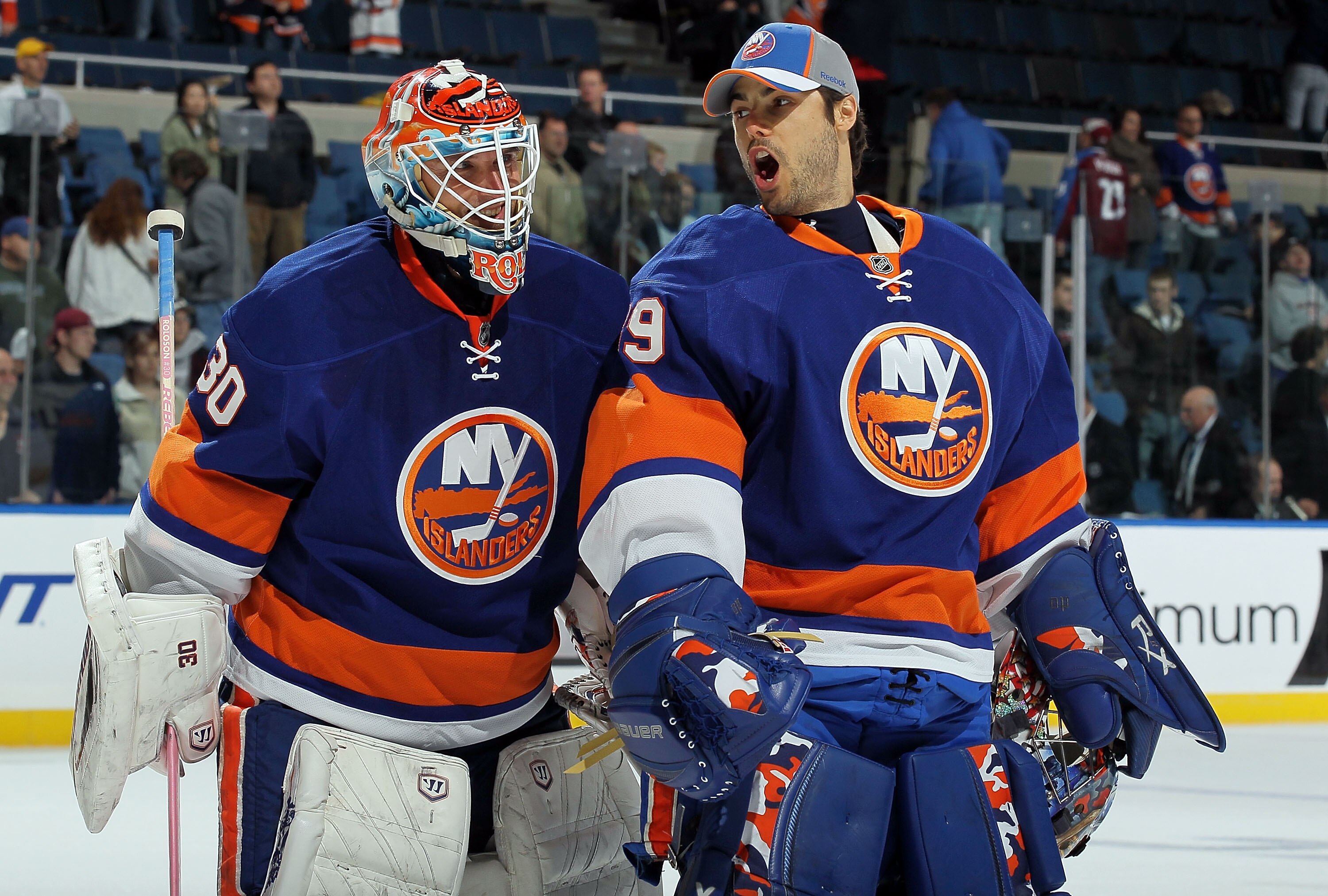 UNIONDALE, NY - OCTOBER 16:  Dwayne Roloson #30 and Rick DiPietro #39 of the New York Islanders celebrate after defeating the Colorado Avalanche on October 16, 2010 at Nassau Coliseum in Uniondale, New York. The Isles defeated the Avalanche 5-2.  (Photo b