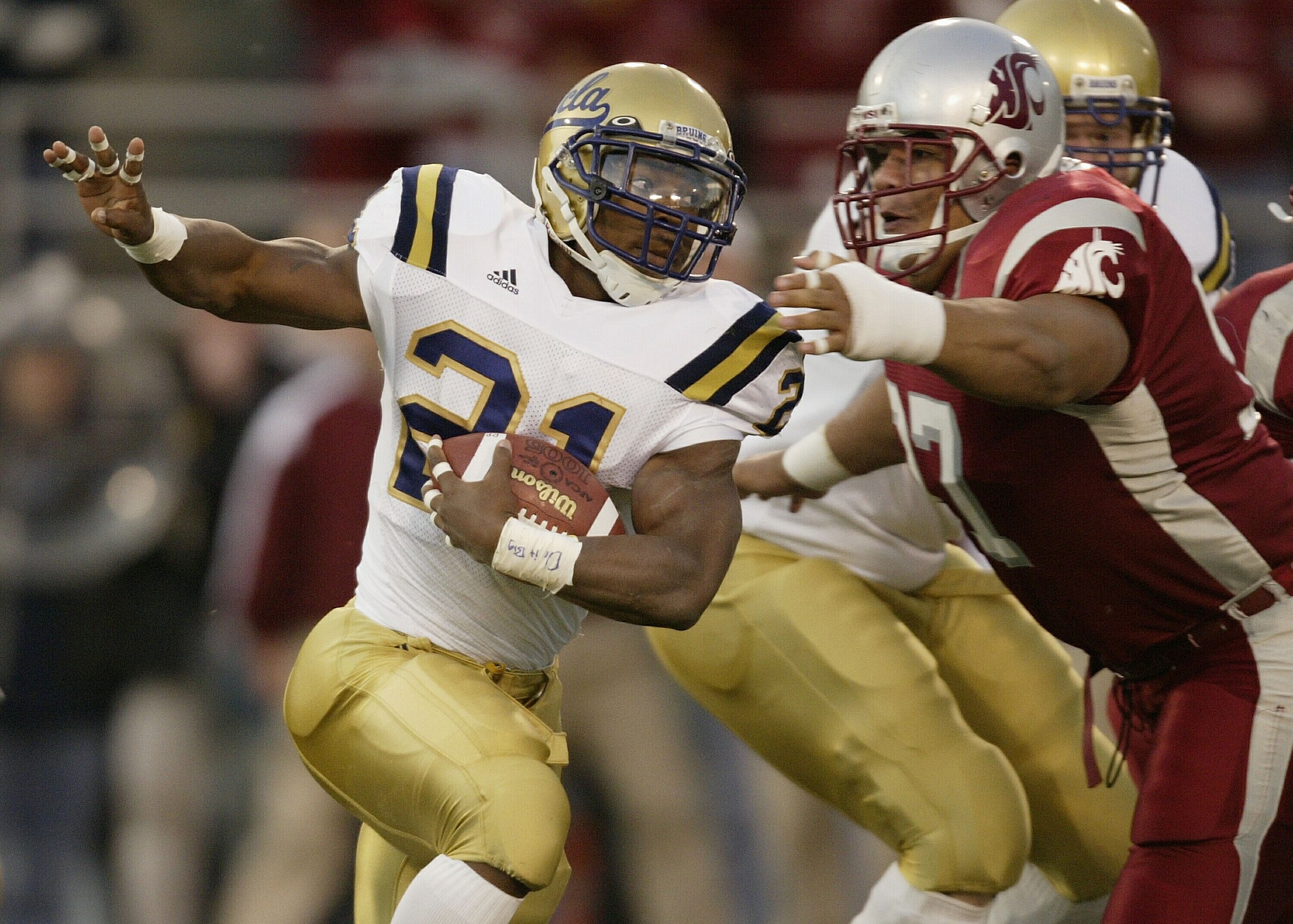 PULLMAN, WA - NOVEMBER 8:  Runningback Maurice Drew #21 of the U.C.L.A. Bruins rushes against Tai Tupai #97 of the Washington State University Cougars on November 8, 2003 at Martin Stadium in Pullman, Washington. (Photo by Otto Greule Jr/Getty Images)