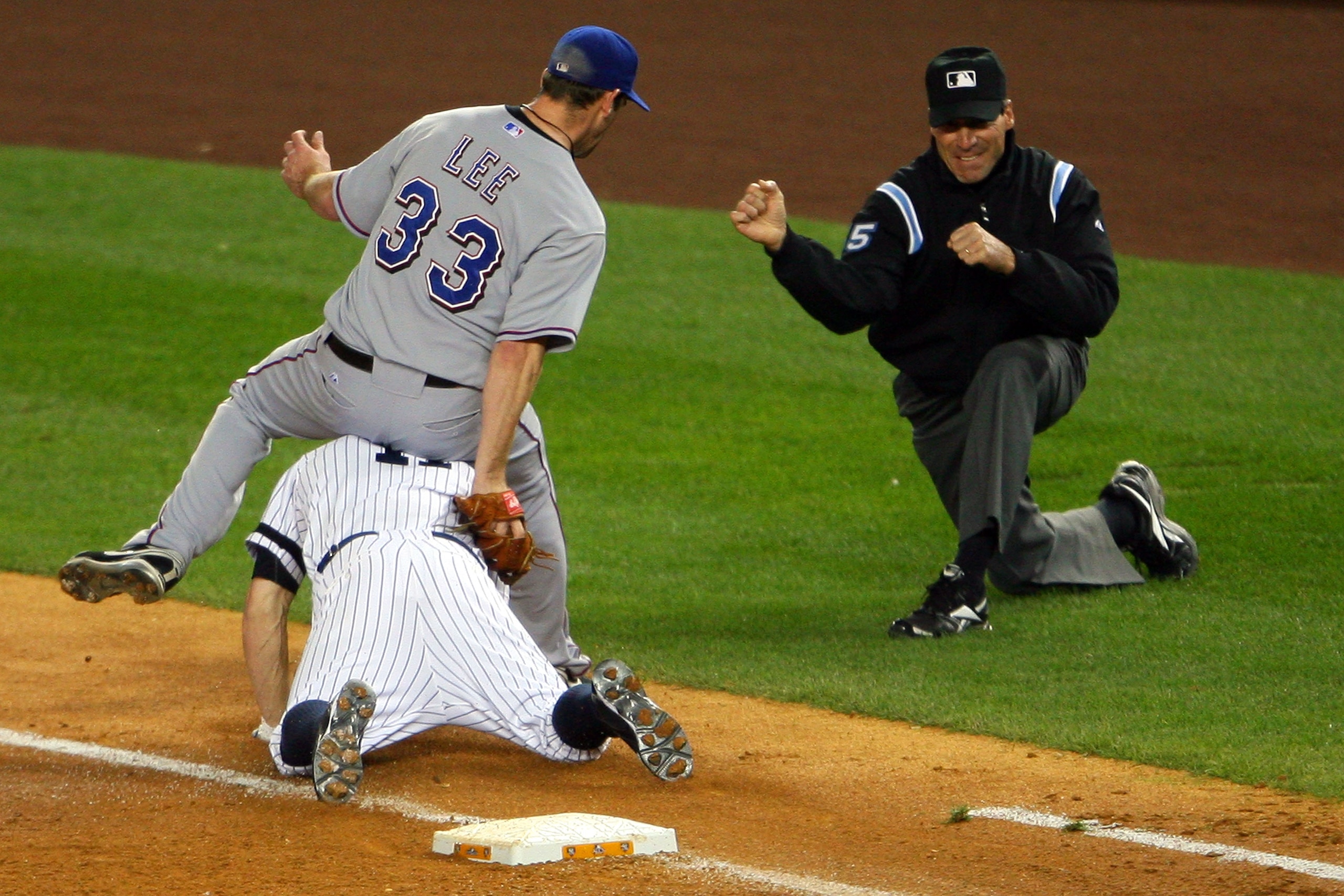 NEW YORK - OCTOBER 18:  Brett Gardner #11 of the New York Yankees is forced out at first base by pitcher Cliff Lee #33 of the Texas Rangers in the bottom of the third inning of Game Three of the ALCS during the 2010 MLB Playoffs at Yankee Stadium on Octob