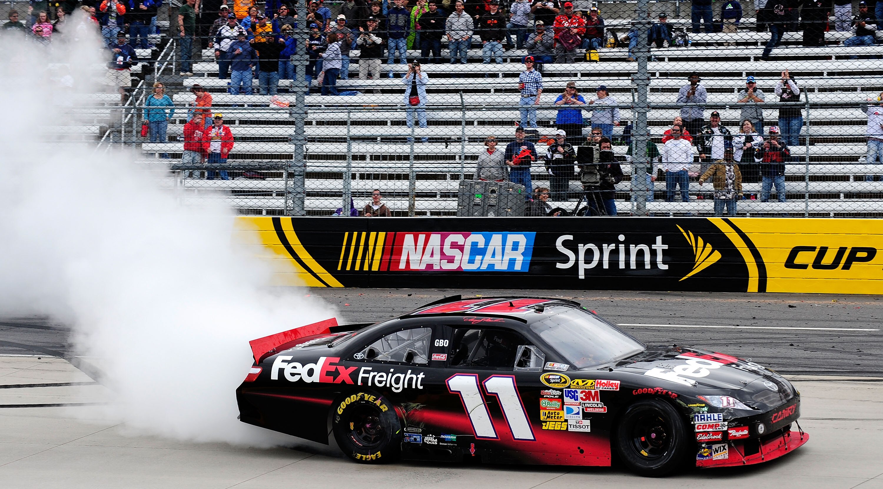 MARTINSVILLE, VA - MARCH 29:  Denny Hamlin celebrates with a burnout in the #11 FedEx Toyota after winning the NASCAR Sprint Cup Series Goody's Fast Pain Relief 500 at Martinsville Speedway on March 29, 2010 in Martinsville, Virginia.  (Photo by Rusty Jar