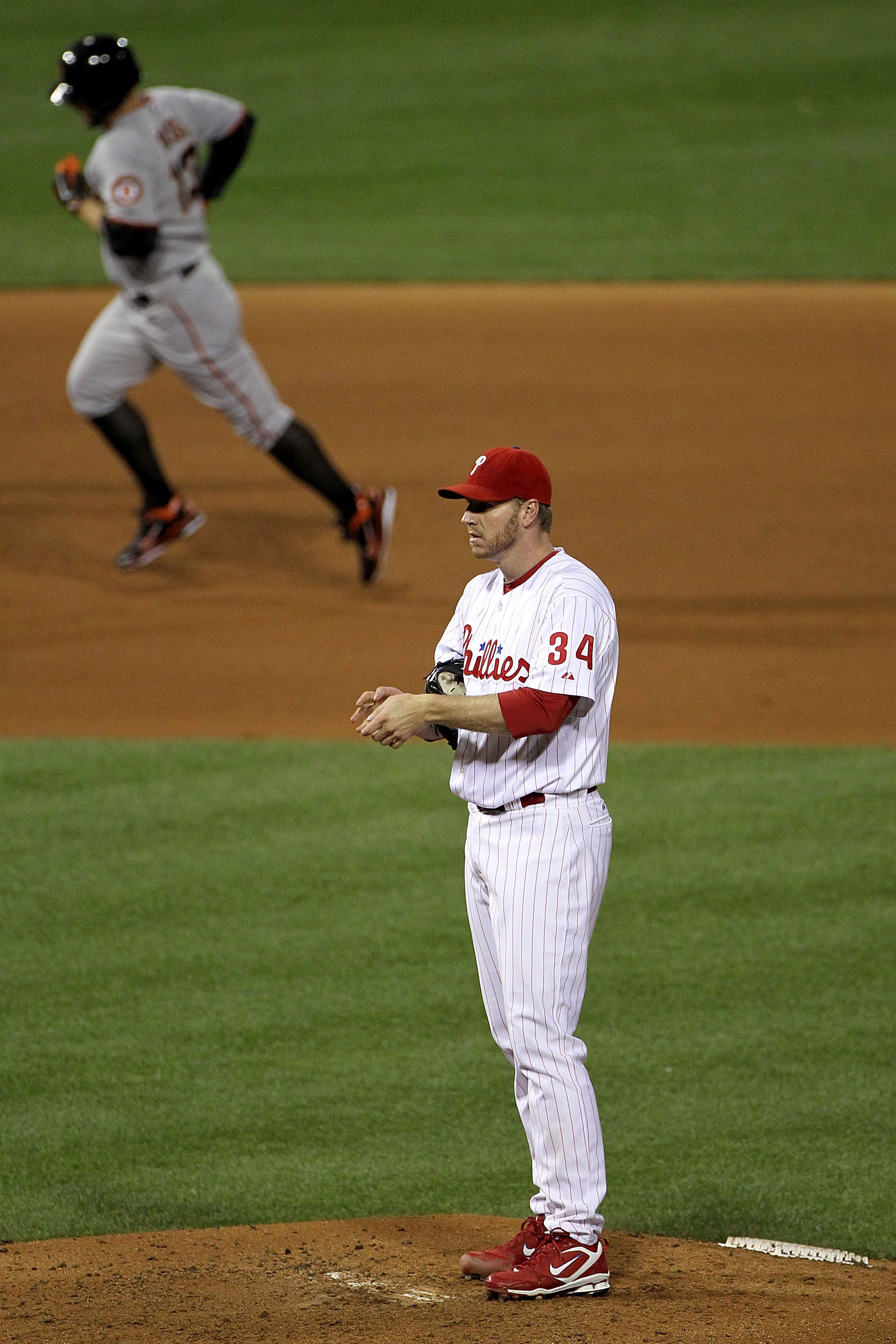 PHILADELPHIA - OCTOBER 16:  (L-R) Cody Ross #13 of the San Francisco Giants rounds the bases past pitcher Roy Halladay #34 of the Philadelphia Phillies after Ross hits a fifth inning home run in Game One of the NLCS during the 2010 MLB Playoffs at Citizen