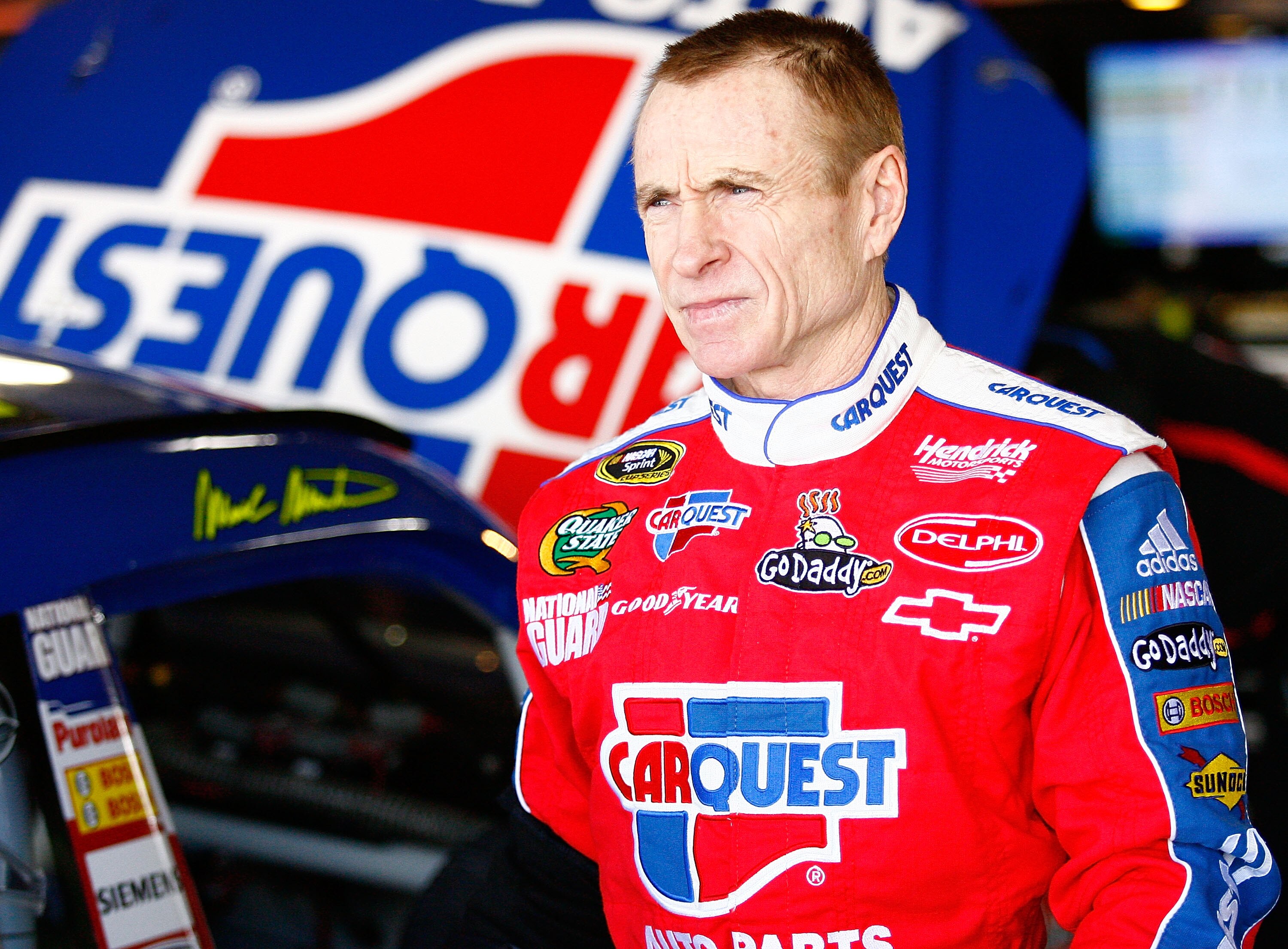MARTINSVILLE, VA - MARCH 27: Mark Martin, driver of the #5 CARQUEST/GoDaddy.com Chevrolet, stands in the garage during practice for the NASCAR Sprint Cup Series Goody's Fast Pain Relief 500 at Martinsville Speedway on March 27, 2010 in Martinsville, Virgi