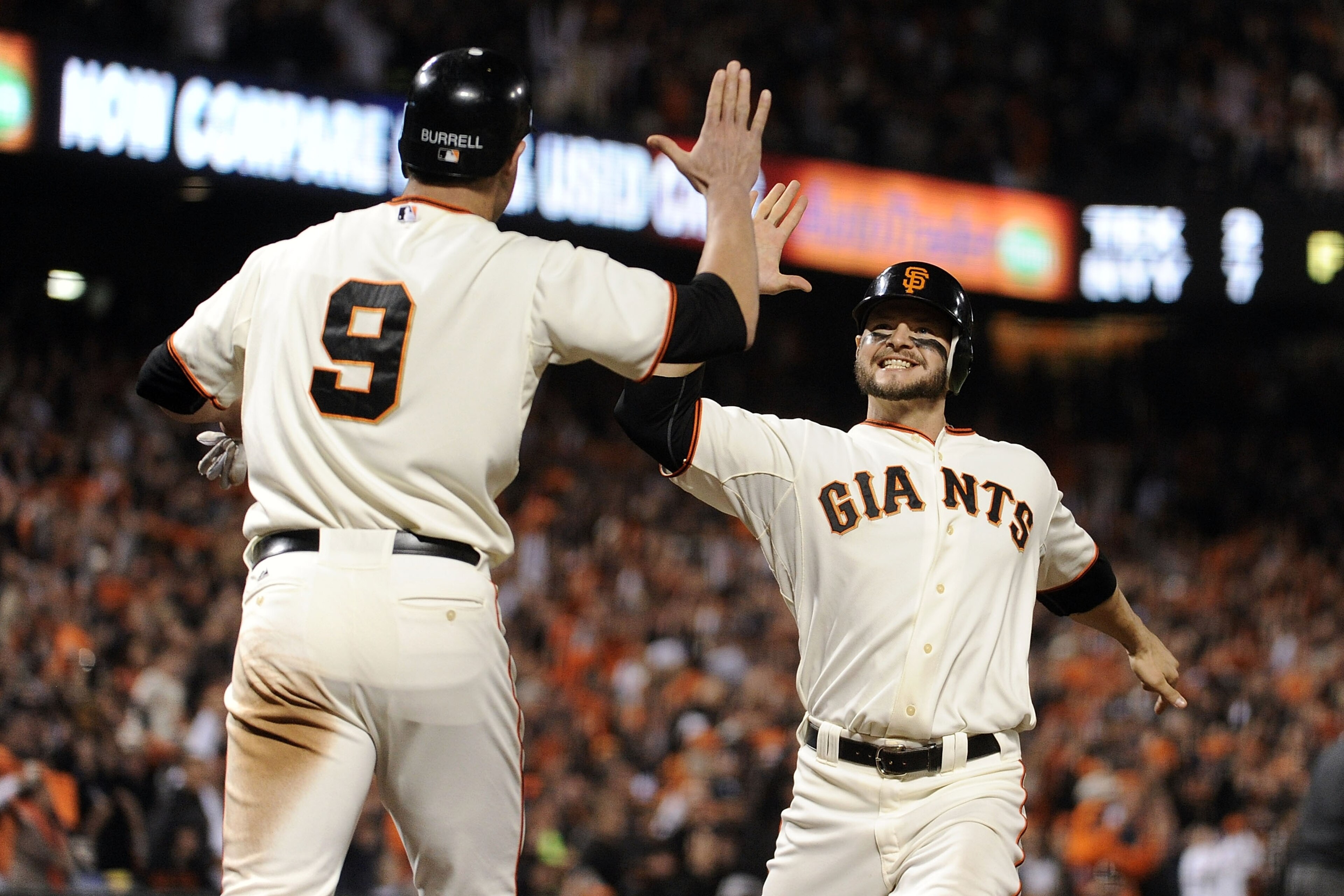 SAN FRANCISCO - OCTOBER 20:  Cody Ross #13 and Pat Burrell #9 of the San Francisco Giants celebrate after scoring on a double by Pablo Sandoval #48 in the sixth inning of Game Four of the NLCS during the 2010 MLB Playoffs at AT&T Park on October 20, 2010