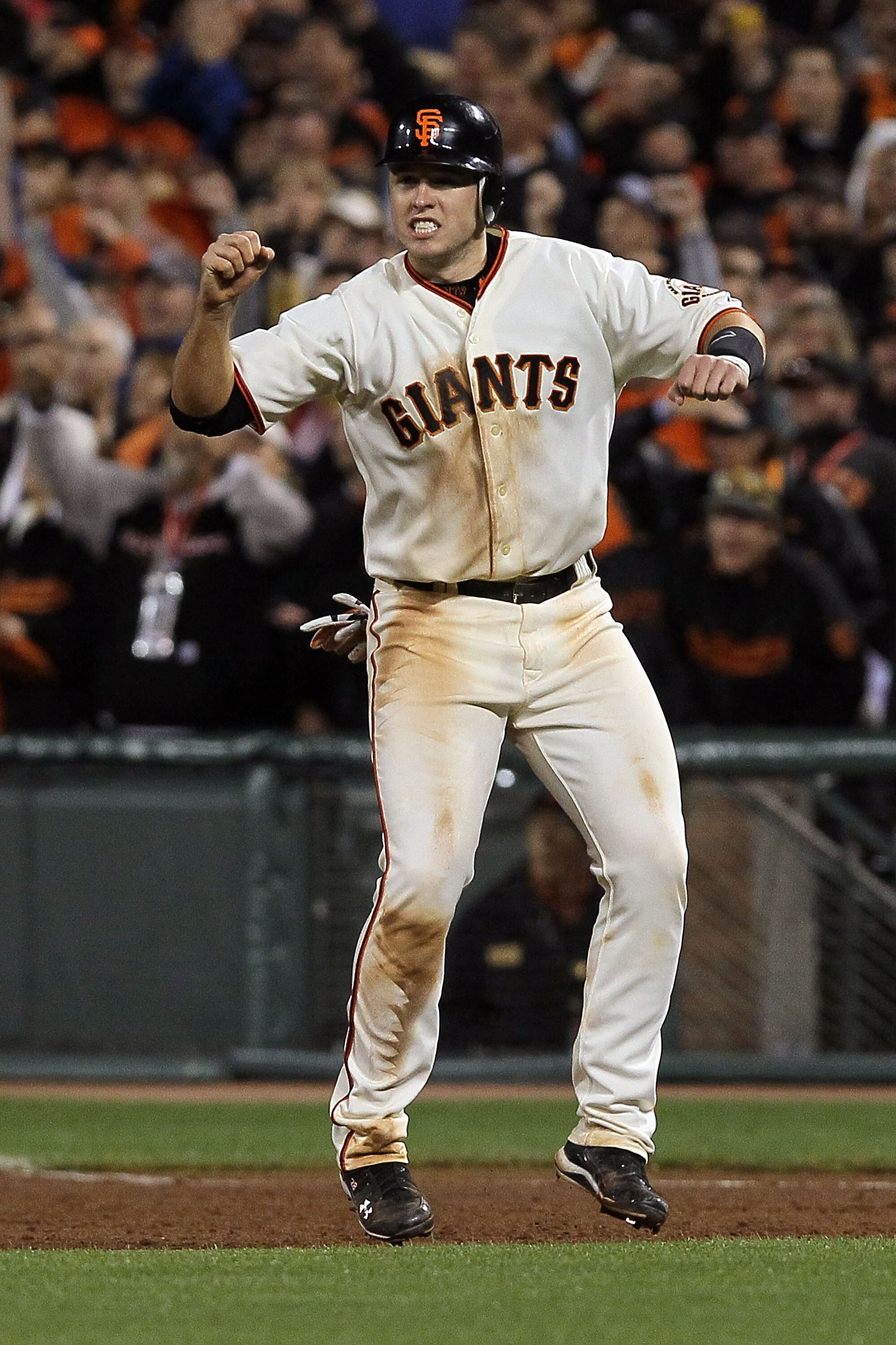 SAN FRANCISCO - OCTOBER 20:  Buster Posey #28 of the San Francisco Giants reacts to Juan Uribe #5 hitting a sacrifice fly, scoring Aubrey Huff #17 to win 6-5 over the Philadelphia Phillies in Game Four of the NLCS during the 2010 MLB Playoffs at AT&T Park