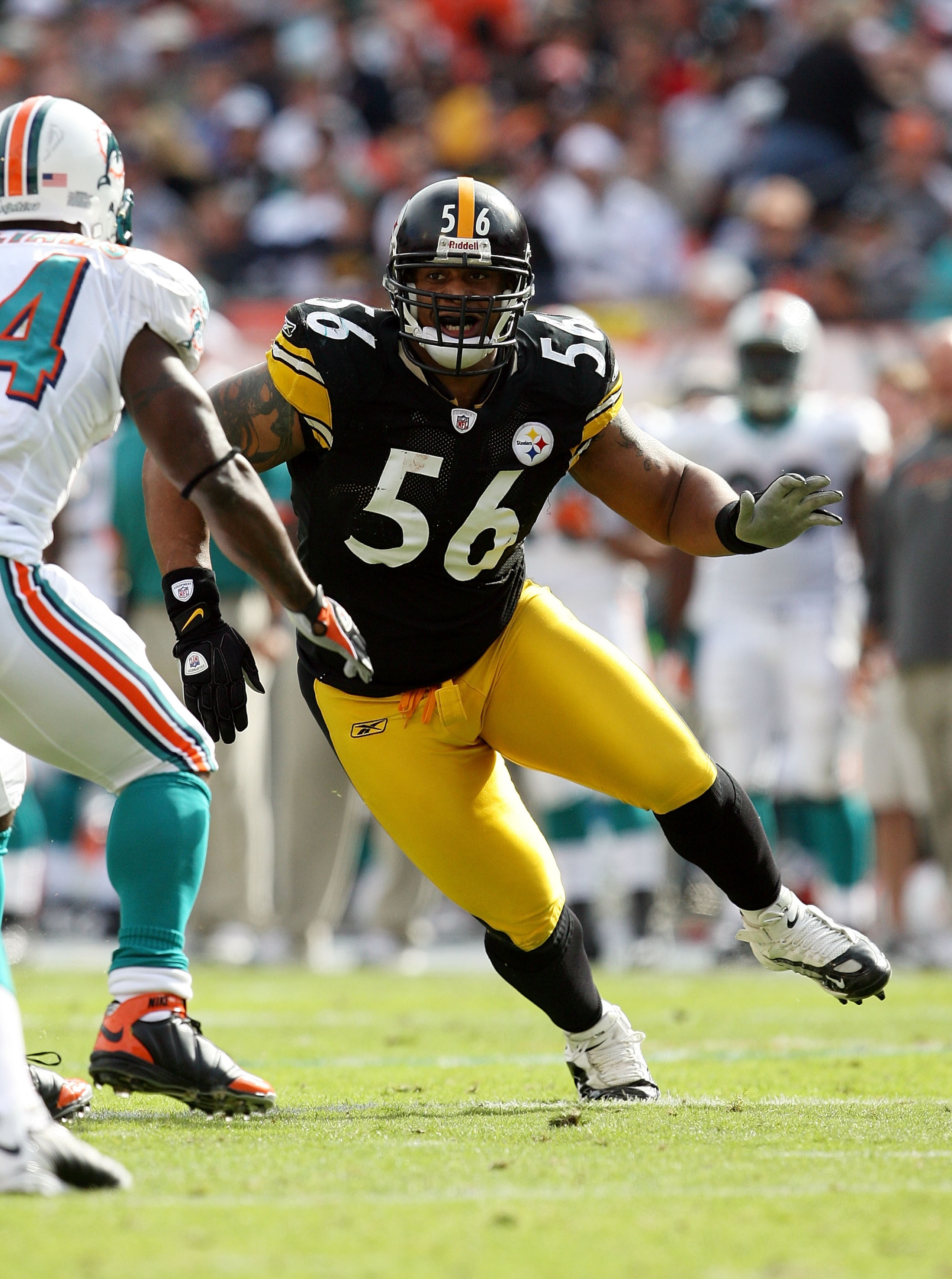 MIAMI - JANUARY 03:  Linebacker LaMarr Woodley #56 of the Pittsburgh Steelers tries to get into the backfield around running back Ricky Williams #34 of the Miami Dolphins at Land Shark Stadium on January 3, 2010 in Miami, Florida. The Steelers defeated th
