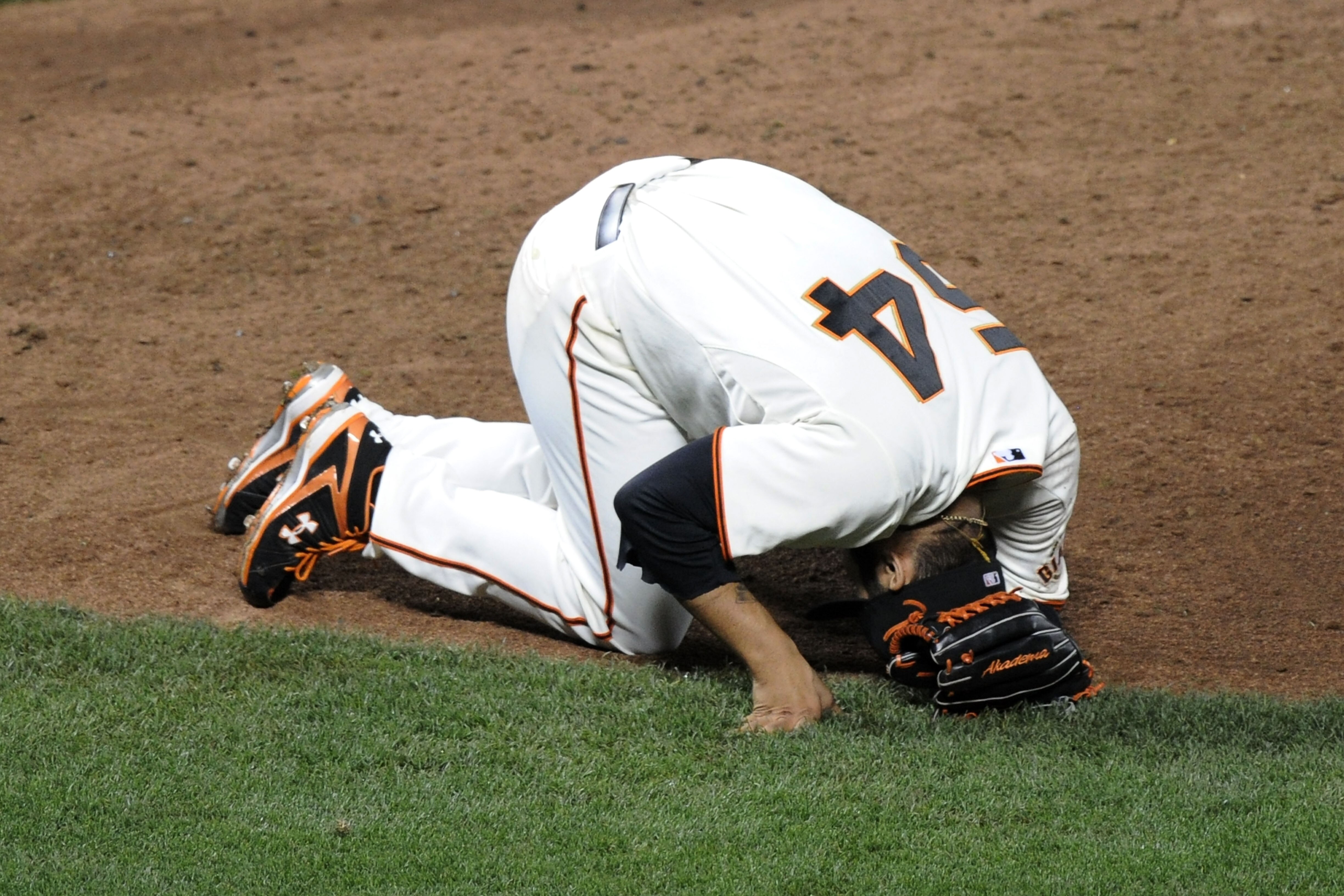 SAN FRANCISCO - OCTOBER 21:  Sergio Romo #54 of the San Francisco Giants lays on the ground after slipping while trying to field a ball hit by Shane Victorino #8 of the Philadelphia Phillies in Game Five of the NLCS during the 2010 MLB Playoffs at AT&T Pa