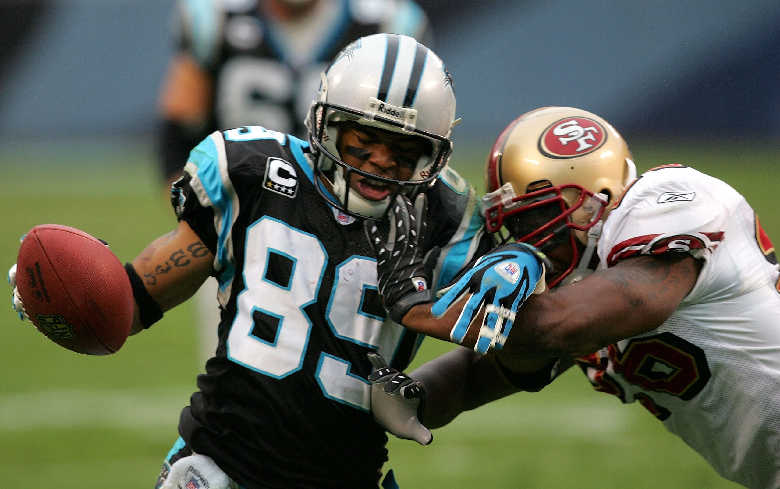 CHARLOTTE, NC - DECEMBER 02:  Steve Smith #89 of the Carolina Panthers is tackled by Mark Roman #26 of the San Francisco 49ers at Bank of America Stadium on December 2, 2007 in Charlotte, North Carolina.  (Photo by Streeter Lecka/Getty Images)