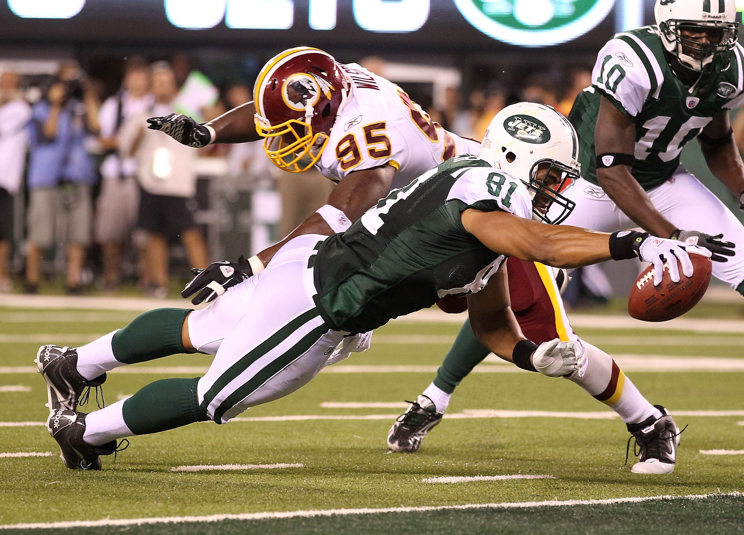 EAST RUTHERFORD, NJ - AUGUST 27:  Dustin Keller #81 of the New York Jets scores a touchdown as Chris Wilson #95 of the Washington Redskins  misses the tackle in the fourth quarter during their preseason game on August 27, 2010 at the New Meadowlands Stadi