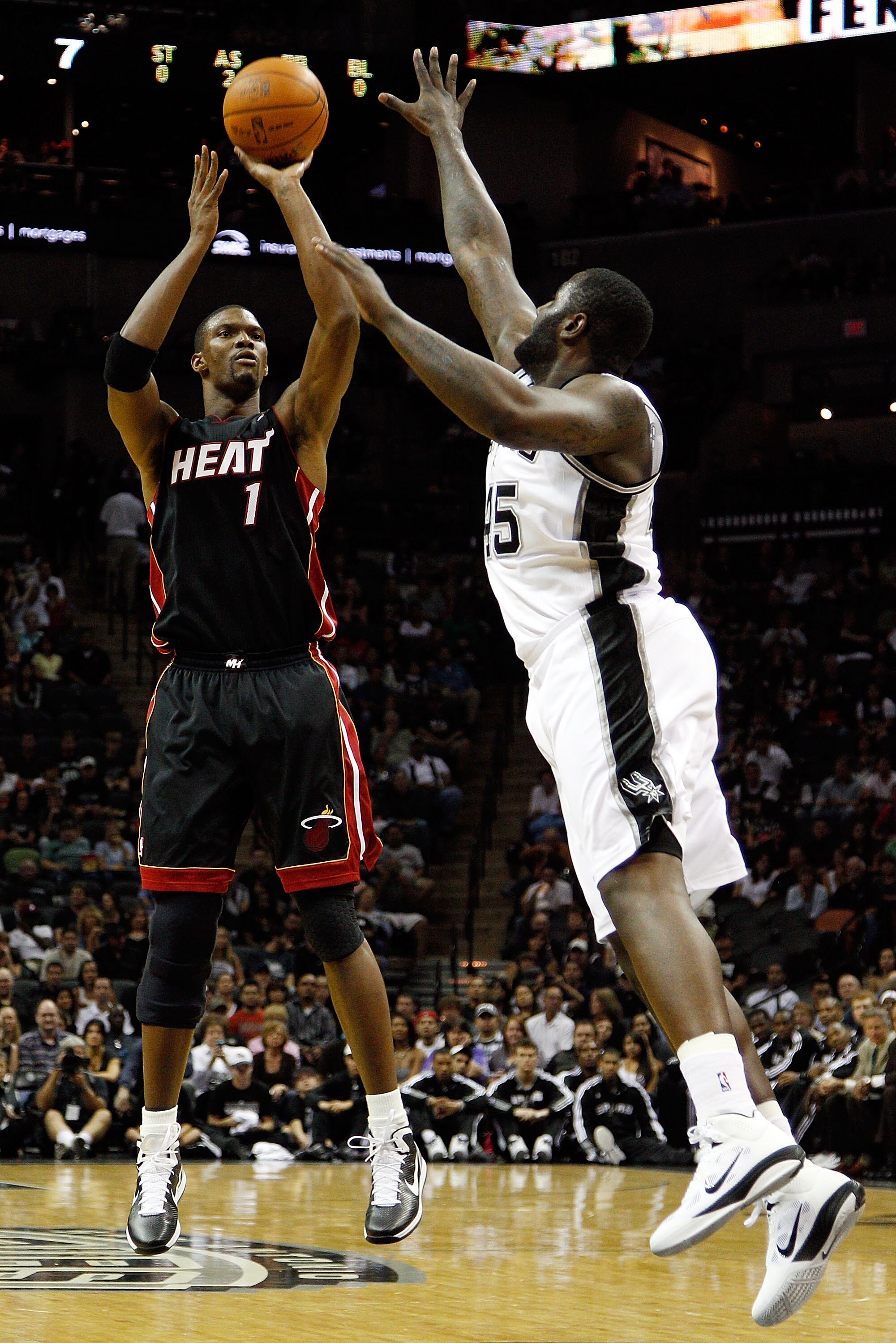 SAN ANTONIO - OCTOBER 09:  Chris Bosh #1 of the Miami Heat makes a shot over DeJuan Blair #45 of the San Antonio Spurs at the AT&T Center on October 9, 2010 in San Antonio, Texas.  NOTE TO USER: User expressly acknowledges and agrees that, by downloading