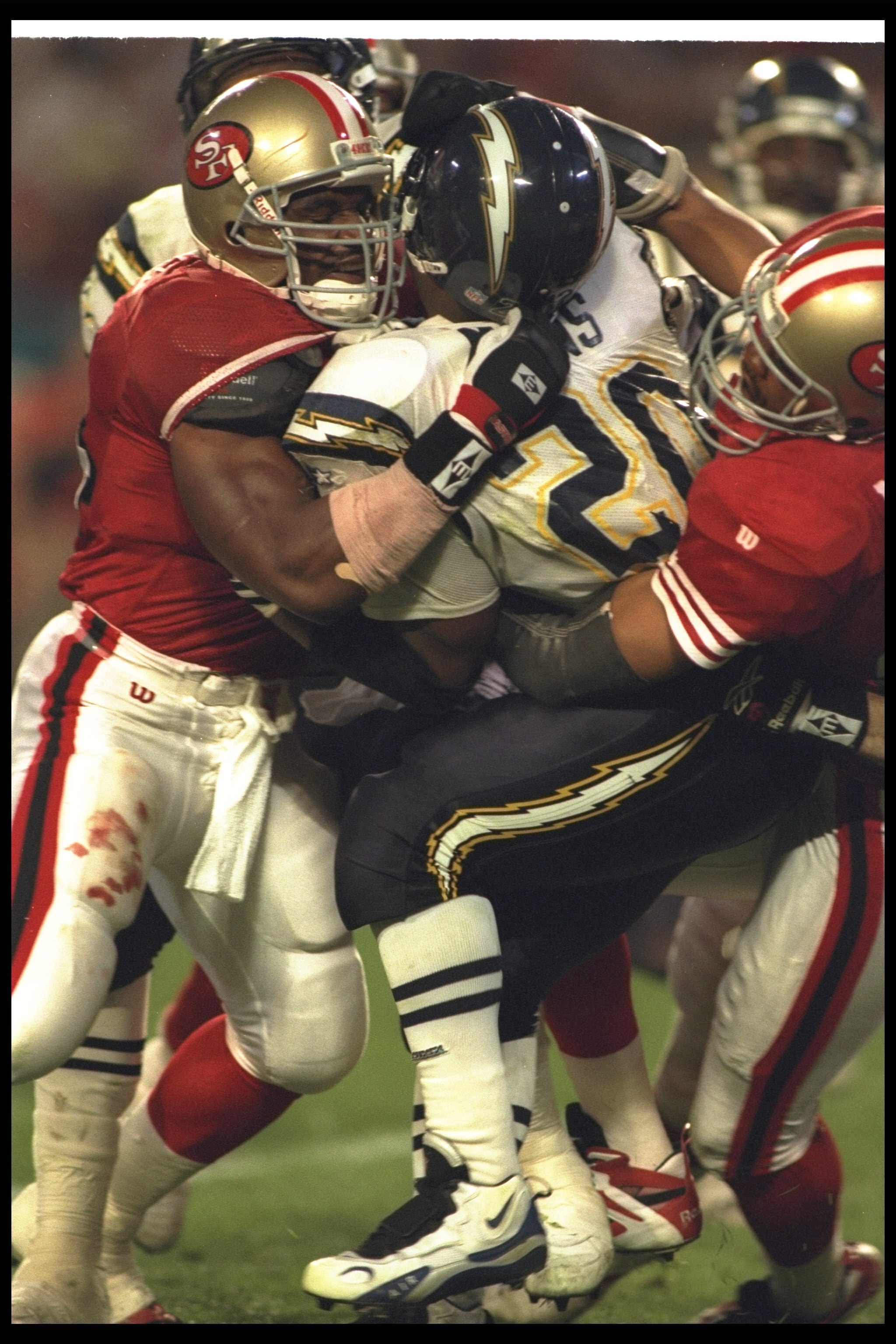 29 Jan 1995:  Running back Natrone Means #20 of the San Diego Chargers is tackled by several San Francisco 49ers players during Super Bowl XXIX at Joe Robbie Stadium in Miami, Florida.  The 49ers won the game, 49-26. Mandatory Credit: Simon Bruty  /Allspo