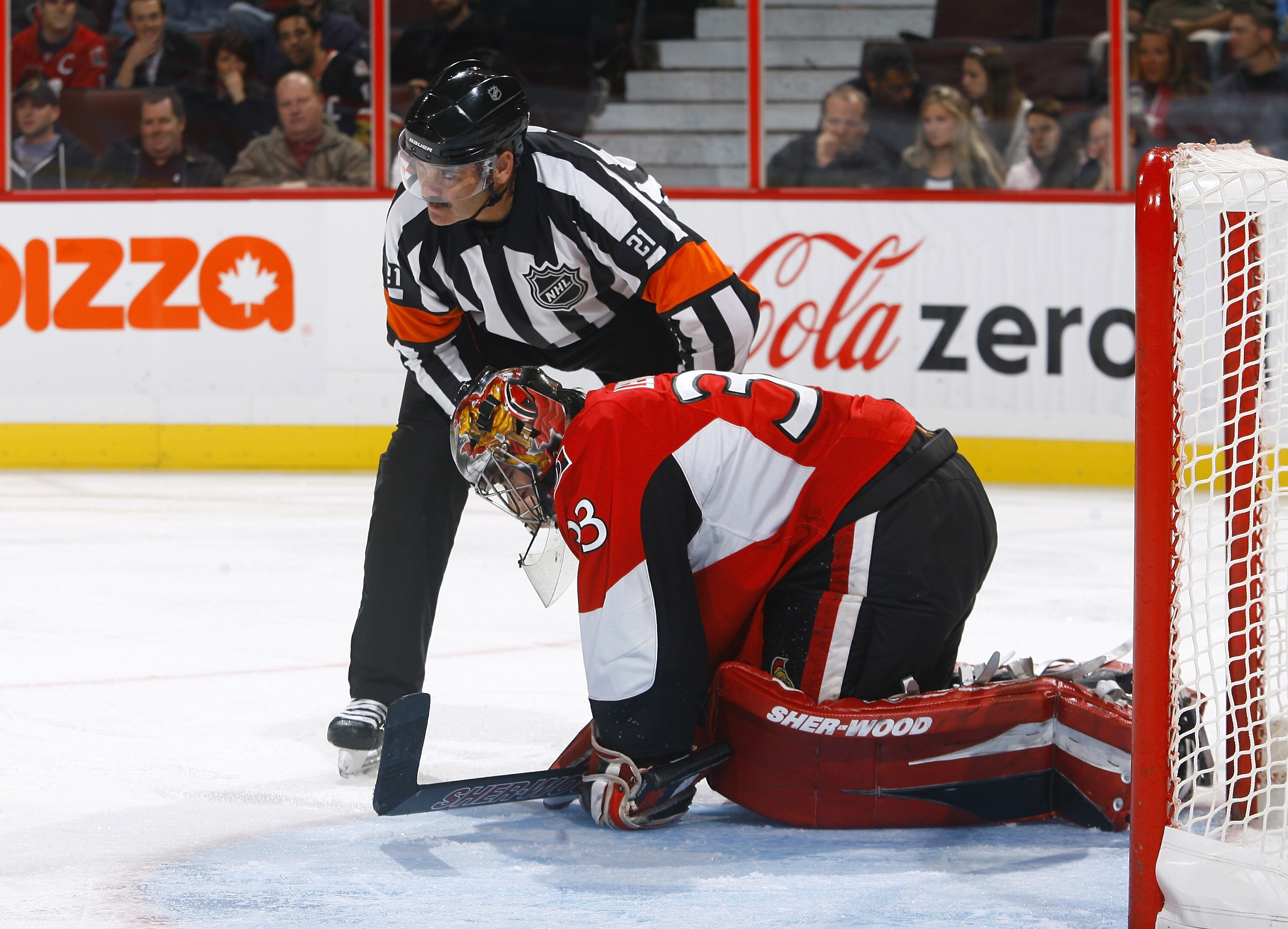 OTTAWA, ON - OCTOBER 14:  Don Van Massenhoven (21) attends to Pascal Leclaire #33 of the Ottawa Senators after suffering a groin injury during a game against the Carolina Hurricanes at Scotiabank Place on October 14, 2010 in Ottawa, Ontario, Canada.  The