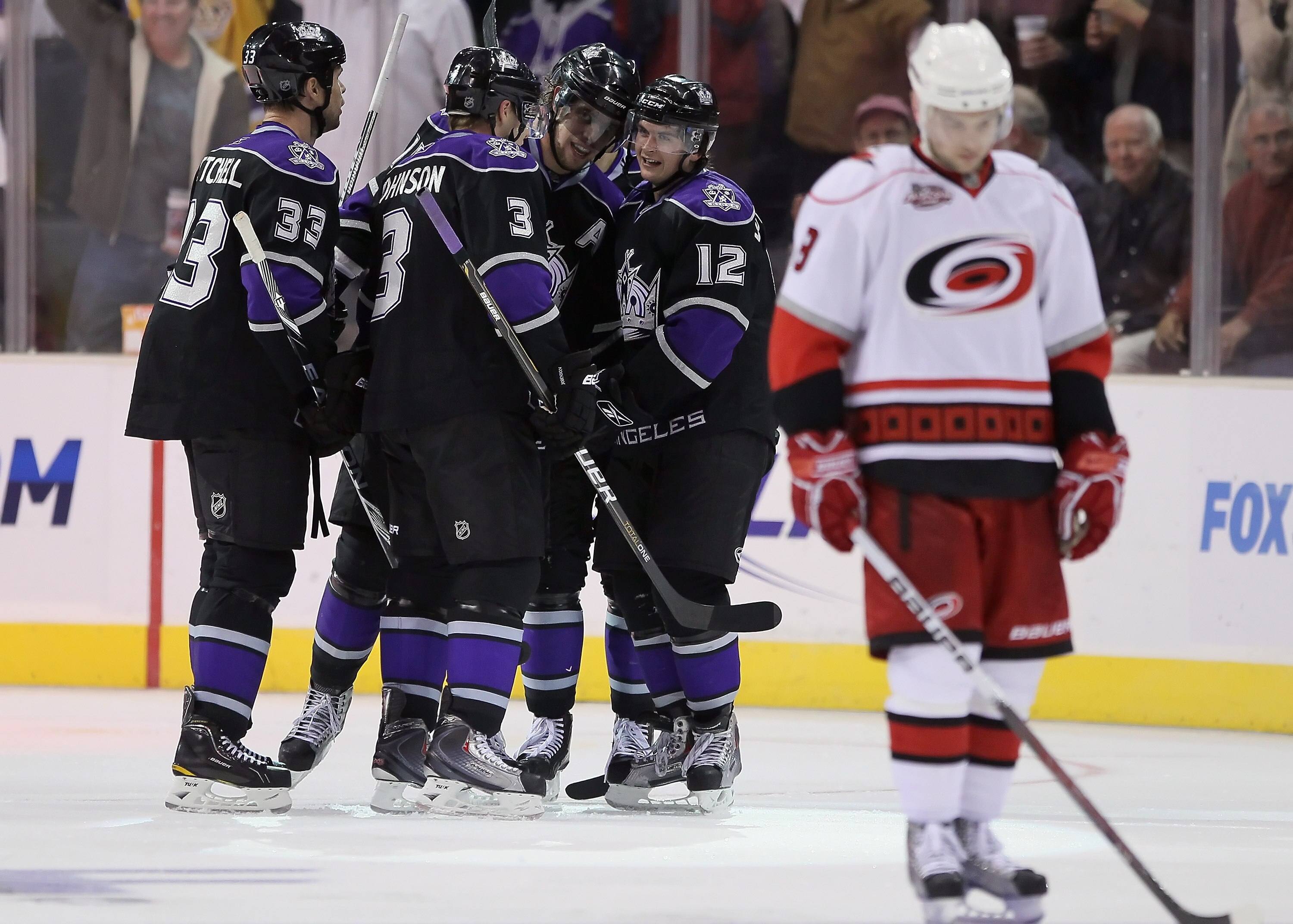 LOS ANGELES, CA - OCTOBER 20:  (L-R) Willie Mitchell #33, Jack Johnson #3, Anze Kopitar #11 and Andrei Loktionov #12 of the Los Angeles Kings celebrate Loktionov's third period goal against the Carolina Hurricanes at Staples Center on October 20, 2010 in