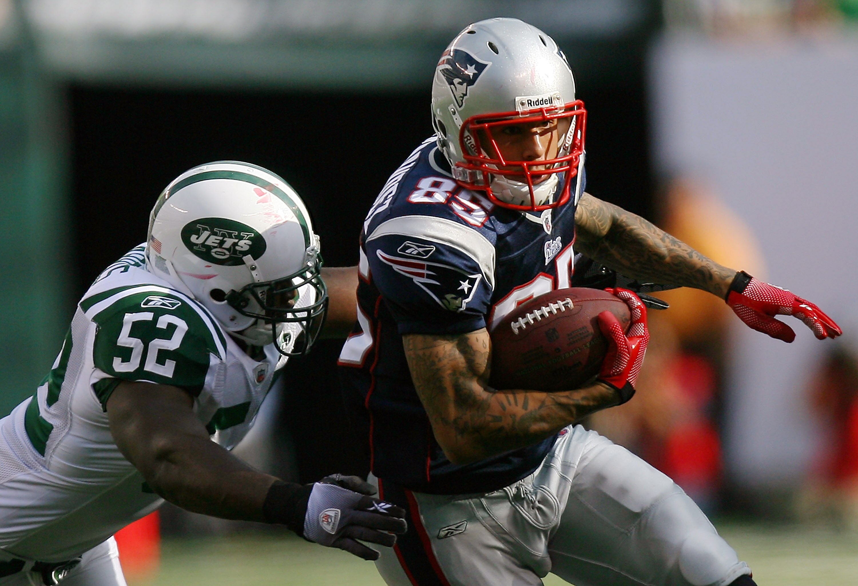 EAST RUTHERFORD, NJ - SEPTEMBER 19:  David Harris #52 of the New York Jets attempts to tackle Aaron Hernandez #85 of the New England Patriots during the first quarter at the New Meadowlands Stadium on September 19, 2010 in East Rutherford, New Jersey.  (P