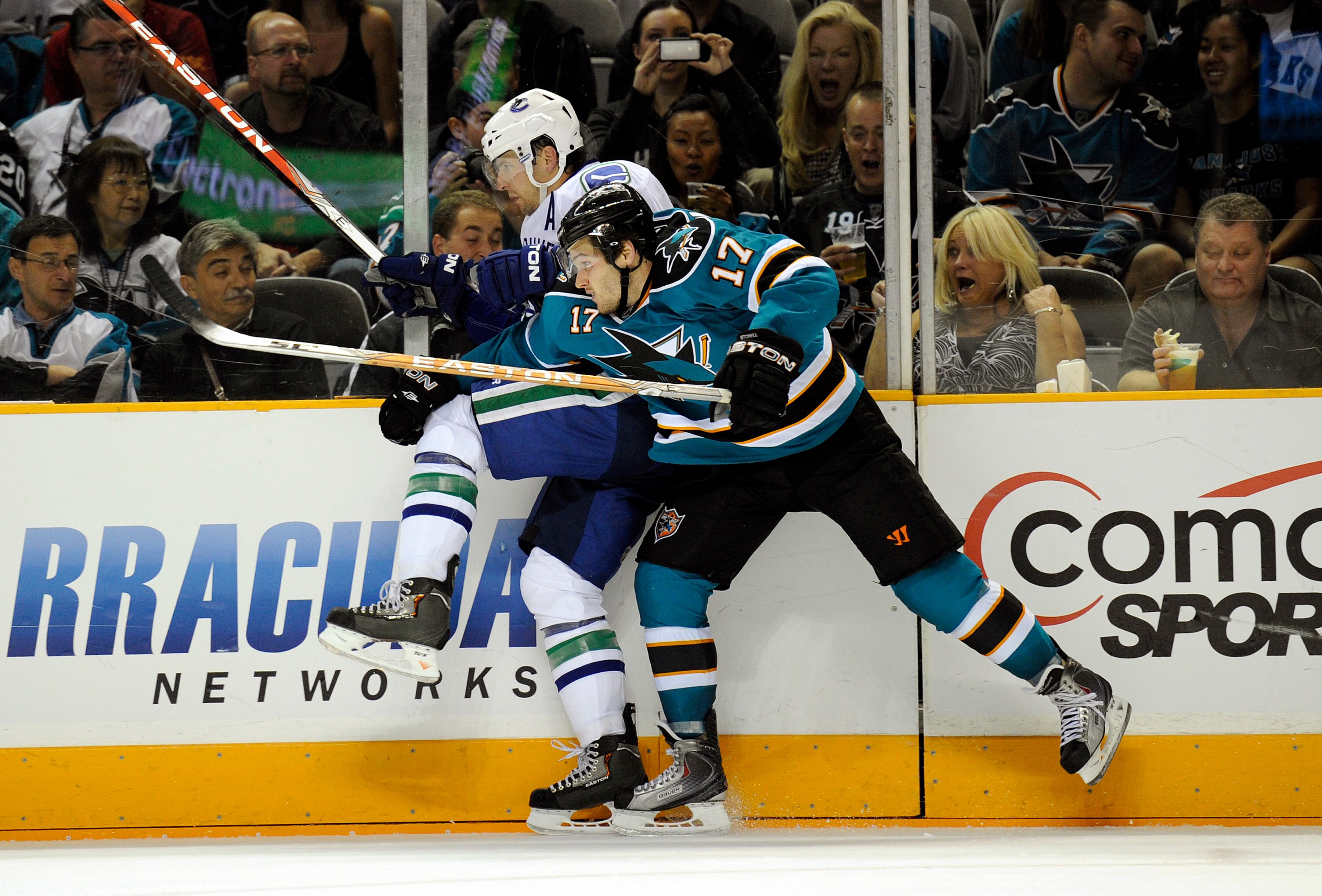 SAN JOSE, CA - SEPTEMBER 29: Torrey Mitchell #17 of the San Jose Sharks checks up against the board Keith Ballard #4 of the Vancouver Canucks during their preseason game on September 29, 2010 at the HP Pavilion in San Jose, California. The Sharks won the
