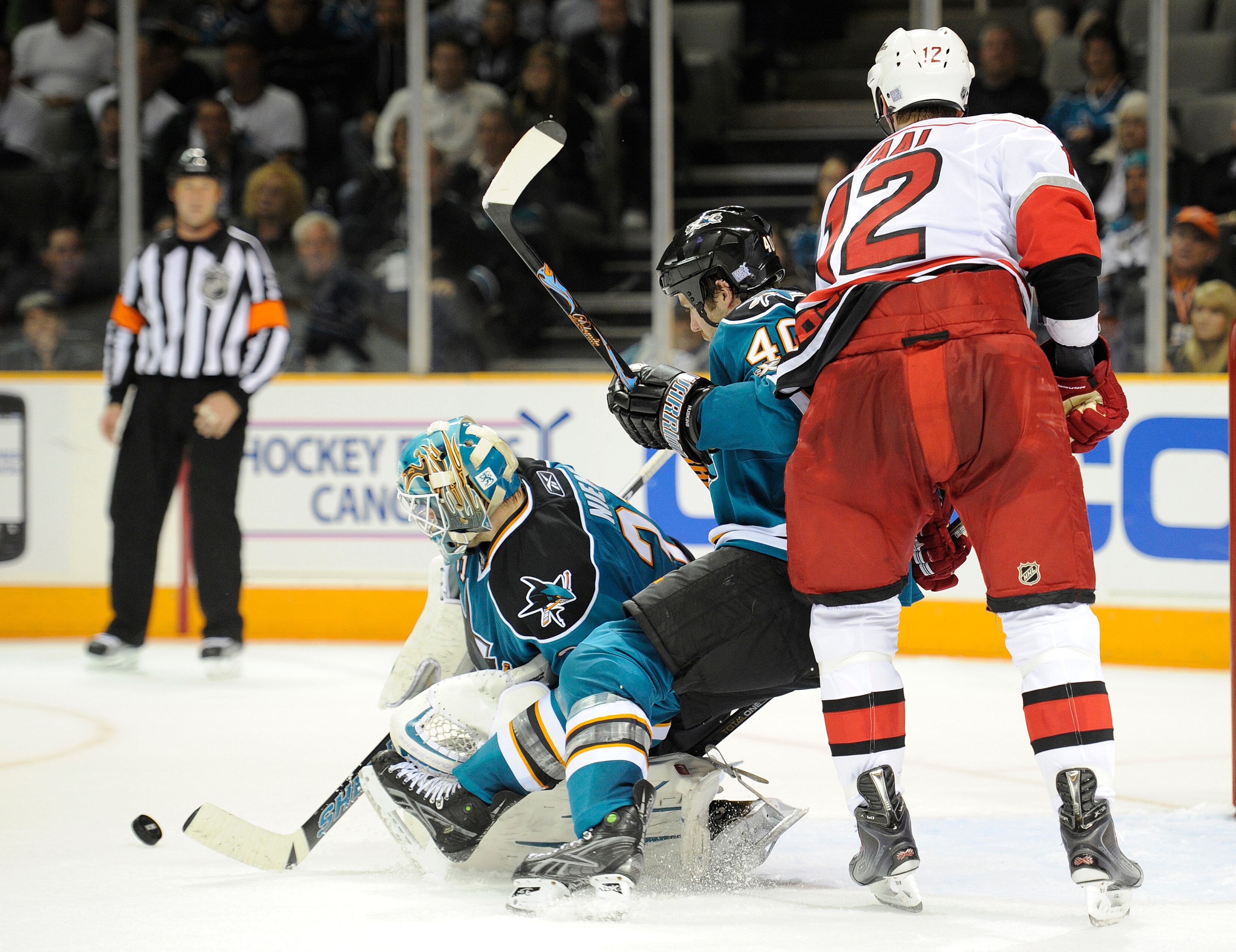 SAN JOSE, CA - OCTOBER 19: Goalie Antti Niemi #31 of the San Jose Sharks gets some help in front of the net from teammate Kent Huskins #40 shielding of Eric Staal #12 of the Carolina Hurricanes during an NHL hockey game at the HP Pavilion October 19, 2010