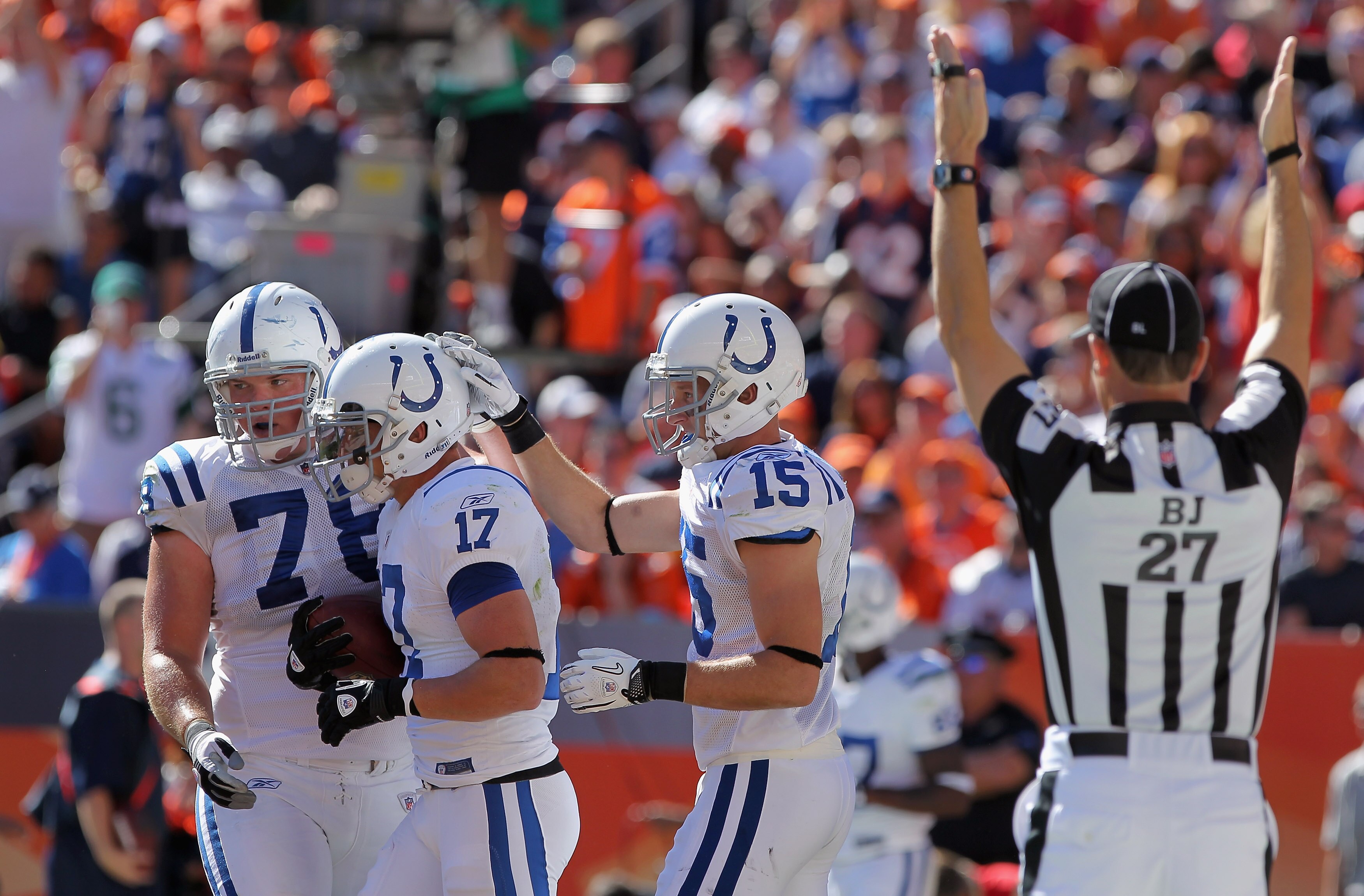 DENVER - SEPTEMBER 26:  Wide receiver Austin Collie #17 of the Indianapolis Colts celebrates his five yard touchdown reception with Mike Pollack #78 and Blair White #15 in the second quarter against the Denver Broncos as back judge Lee Dyer signals at INV