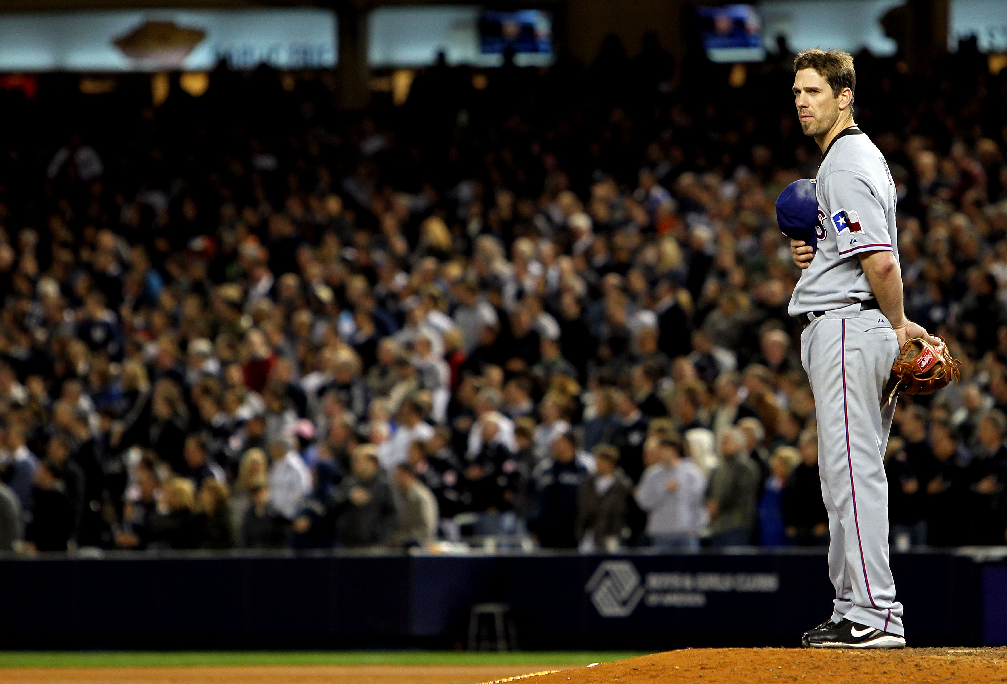 NEW YORK - OCTOBER 18:  Cliff Lee #33 of the Texas Rangers stands on the mound for the performance of 'Gob Bless America' against the New York Yankees in Game Three of the ALCS during the 2010 MLB Playoffs at Yankee Stadium on October 18, 2010 in New York