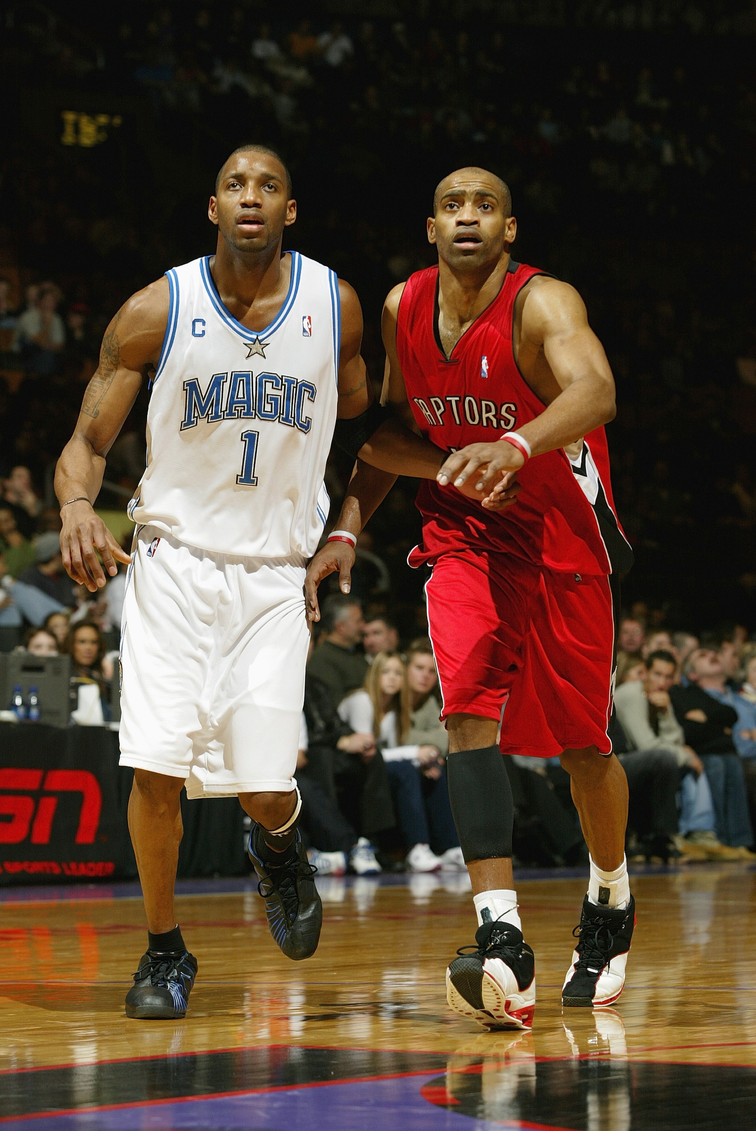 TORONTO - DECEMBER 21:  Tracy McGrady #1 of the Orlando Magic stands next to Vince Carter #15 of the Toronto Raptors during the game on December 21, 2003 at the Air Canada Centre in Toronto, Canada.  McGrady and Carter are cousins. The Magic won 104-93.