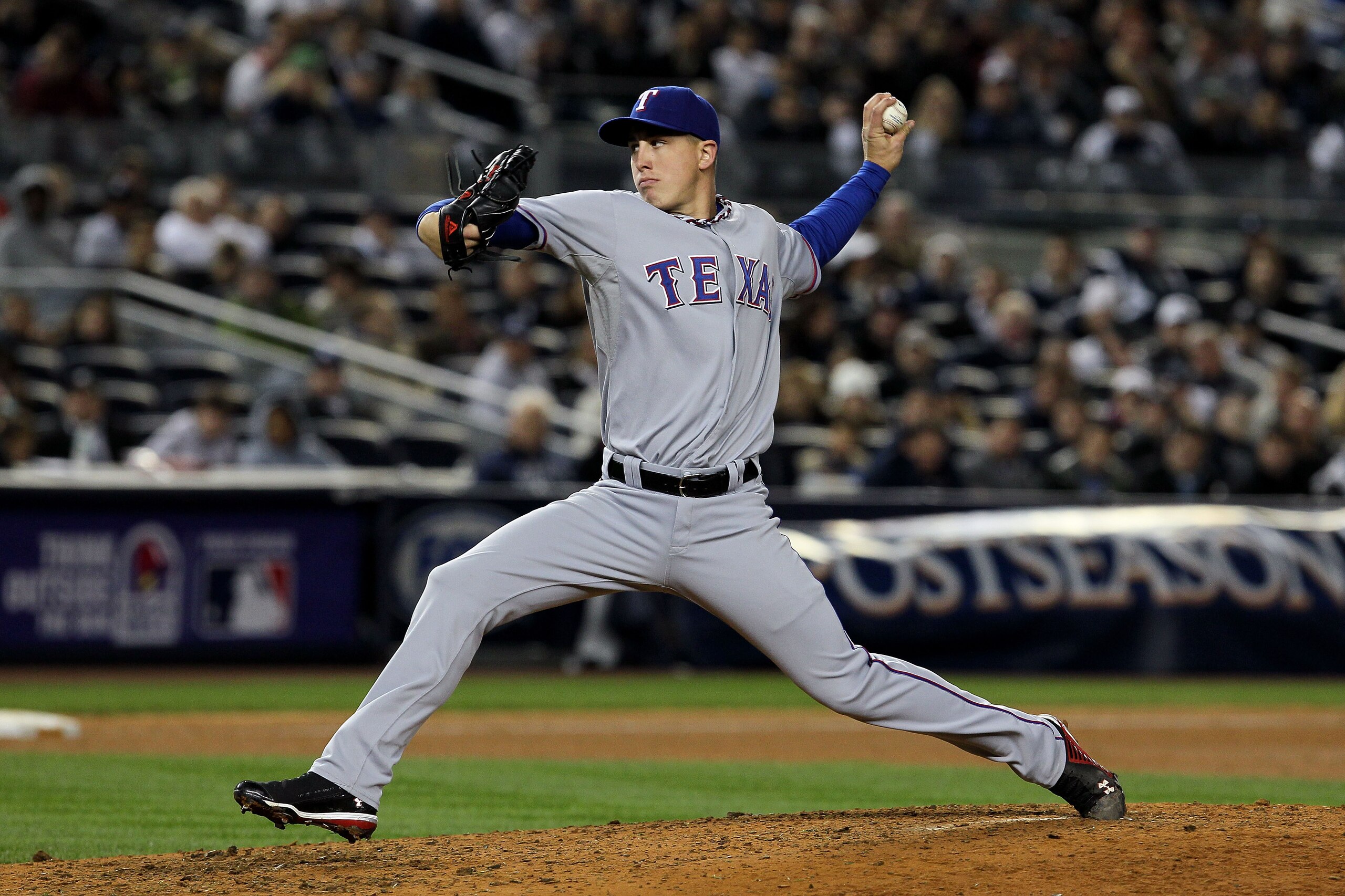 NEW YORK - OCTOBER 19:  Derek Holland #45 of the Texas Rangers pitches against the New York Yankees in Game Four of the ALCS during the 2010 MLB Playoffs at Yankee Stadium on October 19, 2010 in the Bronx borough of New York City.  (Photo by Jim McIsaac/G