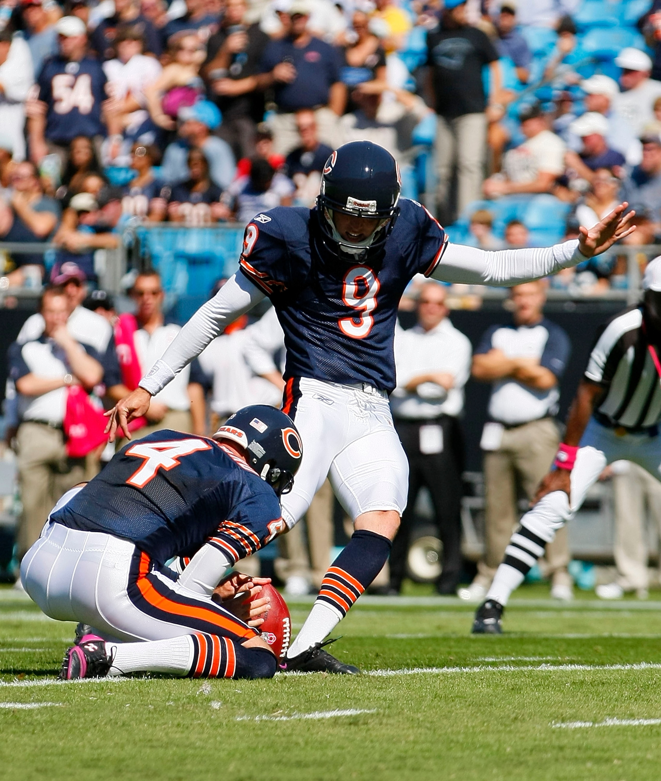 CHARLOTTE, NC - OCTOBER 10: Place kicker Robbie Gould #9 of the Chicago Bears kicks a field goal out of the hold of punter Brad Maynard #4 of the Chicago Bears against the Carolina Panthers at Bank of America Stadium on October 10, 2010 in Charlotte, Nort