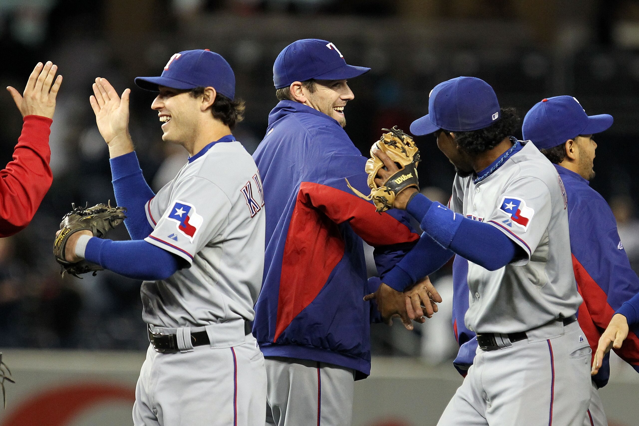 NEW YORK - OCTOBER 18:  (L-R) Ian Kinsler #5, Cliff Lee #33 and Elvis Andrus #1 of the Texas Rangers celebrate after the Rangers won 8-0 against the New York Yankees in Game Three of the ALCS during the 2010 MLB Playoffs at Yankee Stadium on October 18, 2