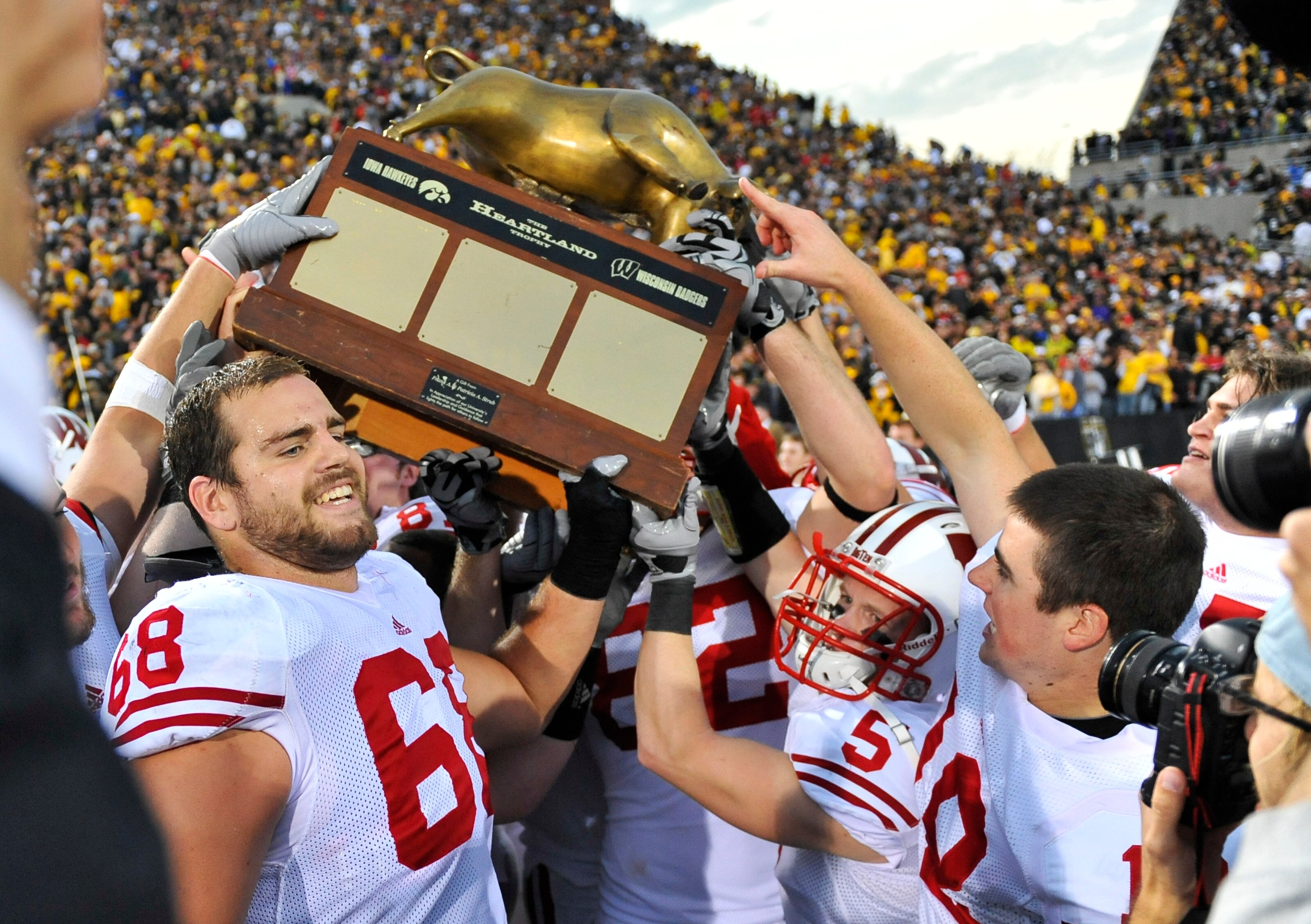 IOWA CITY, IA - OCTOBER 23: Offensive lineman Gabe Carimi #68 of the Wisconsin Badgers holds the Heartland Trophy with his teammates as they celebrate their victory of the University of Iowa Hawkeyes at Kinnick Stadium on October 23, 2010 in Iowa City, Io IOWA CITY, IA - OCTOBER 23: Offensive lineman Gabe Carimi #68 of the Wisconsin Badgers holds the Heartland Trophy with his teammates as they celebrate their victory of the University of Iowa Hawkeyes at Kinnick Stadium on October 23, 2010 in Iowa City, Io
