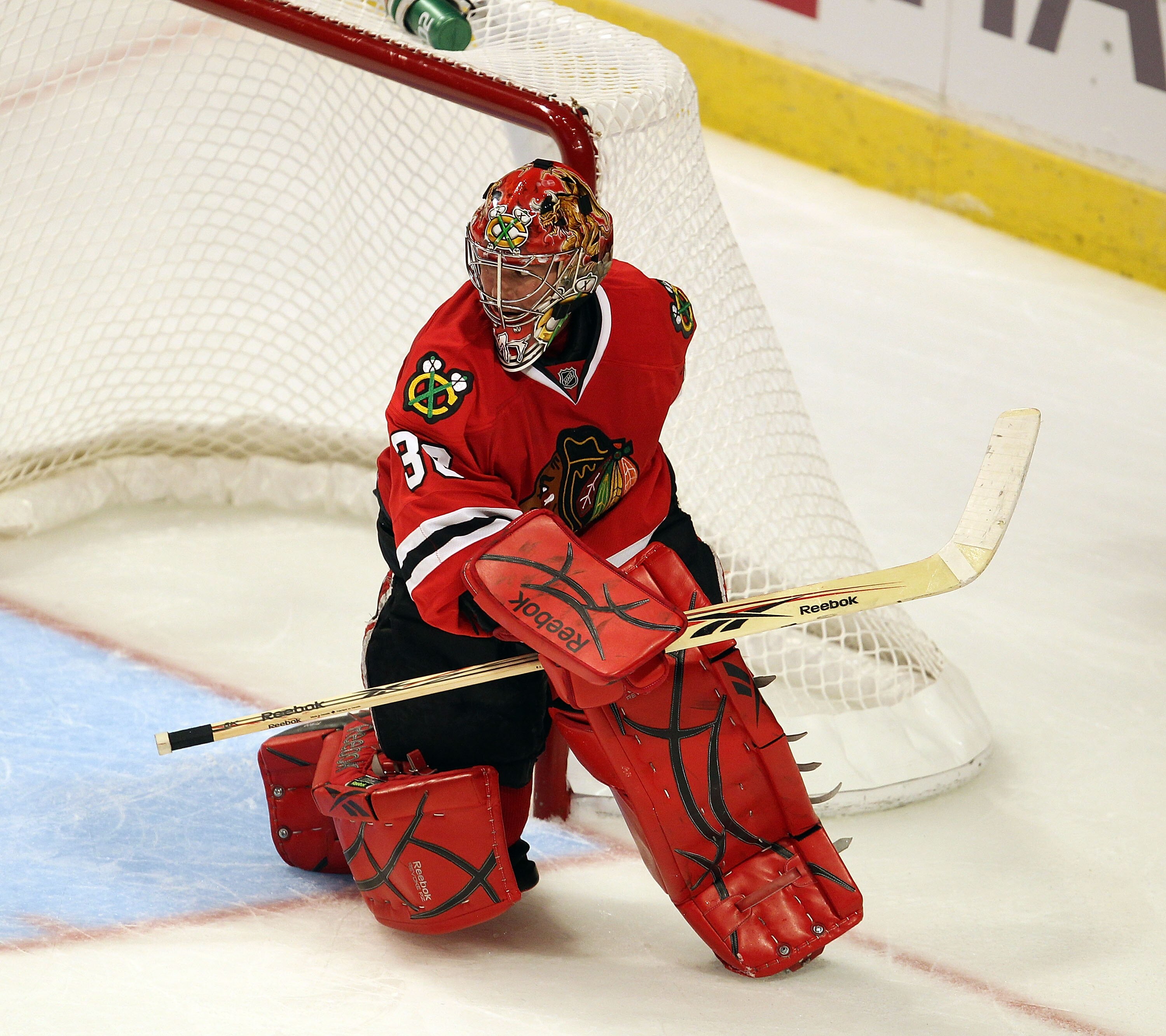 CHICAGO - OCTOBER 09: Marty Turco #30 of the Chicago Blackhawks keeps his eyes on the puck against the Detroit Red Wings during the Blackhawks season home opening game at the United Center on October 9, 2010 in Chicago, Illinois. The Red Wings defeated th