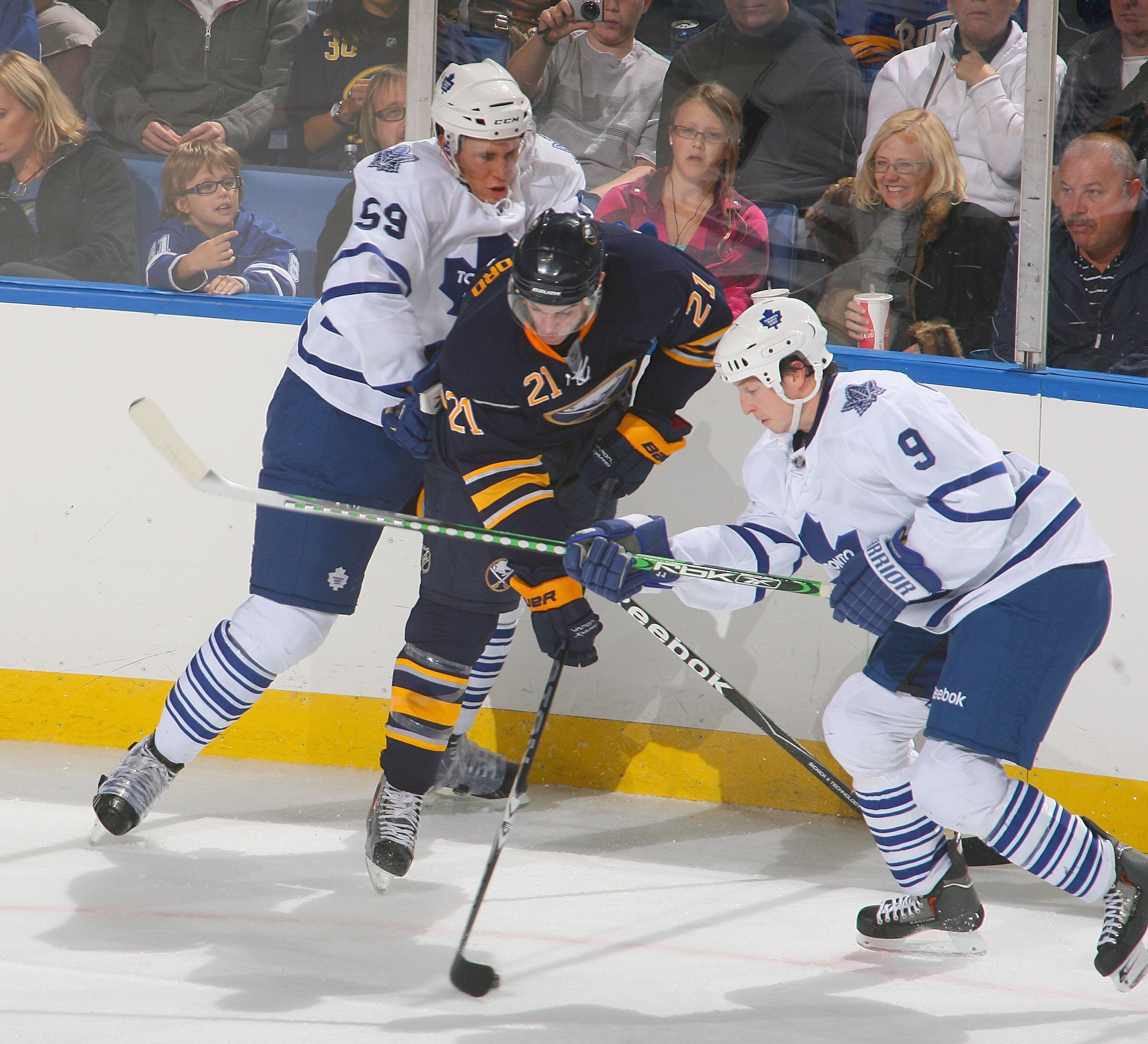 BUFFALO, NY - SEPTEMBER 25: Drew Stafford #21 of the Buffalo Sabres controls the puck between Keith Aulie #59 and Colby Armstrong #9 of the Toronto Maple Leafs at HSBC Arena on September 25, 2010 in Buffalo, New York.  (Photo by Rick Stewart/Getty Images)