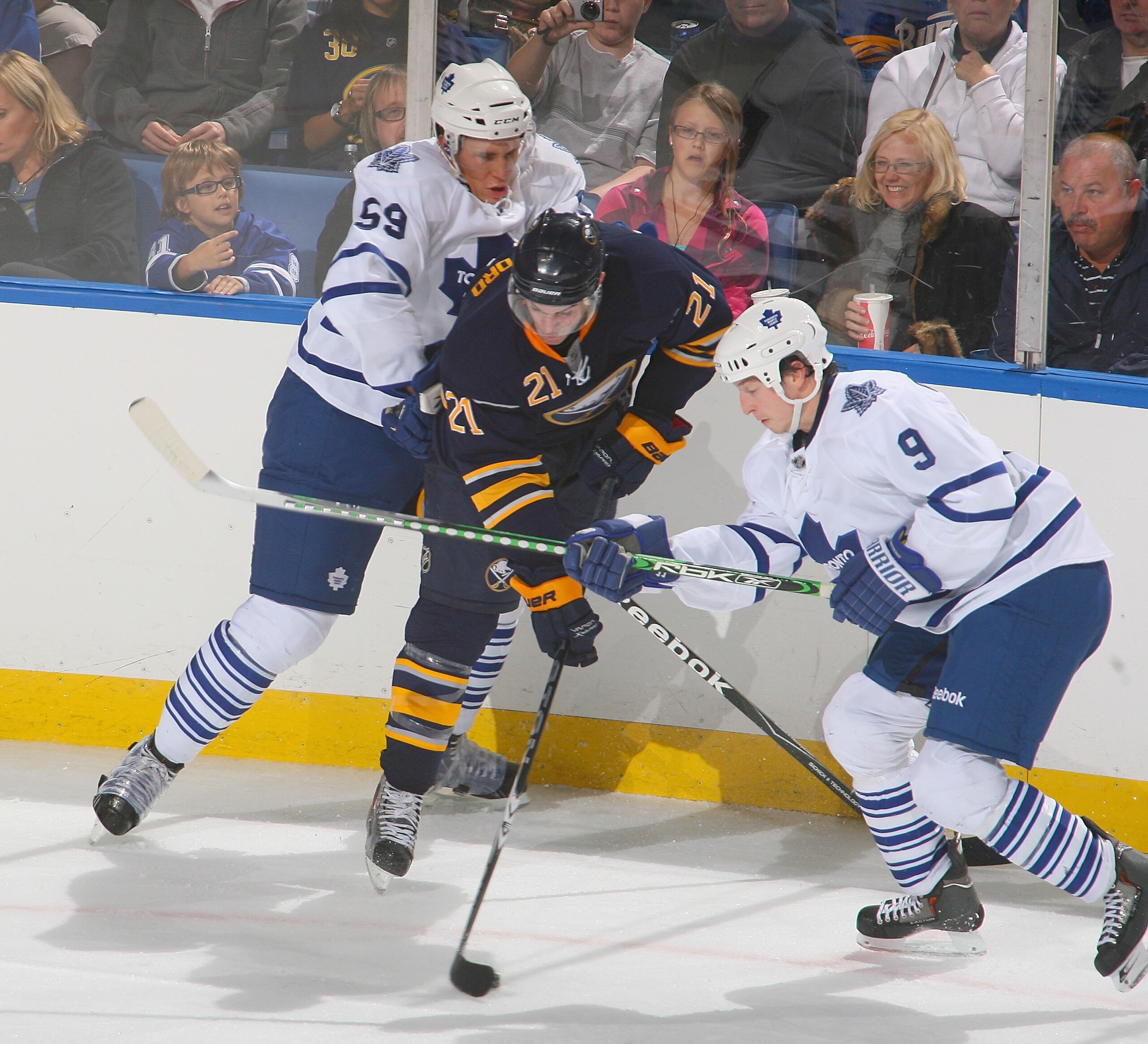 BUFFALO, NY - SEPTEMBER 25: Drew Stafford #21 of the Buffalo Sabres controls the puck between Keith Aulie #59 and Colby Armstrong #9 of the Toronto Maple Leafs at HSBC Arena on September 25, 2010 in Buffalo, New York.  (Photo by Rick Stewart/Getty Images)