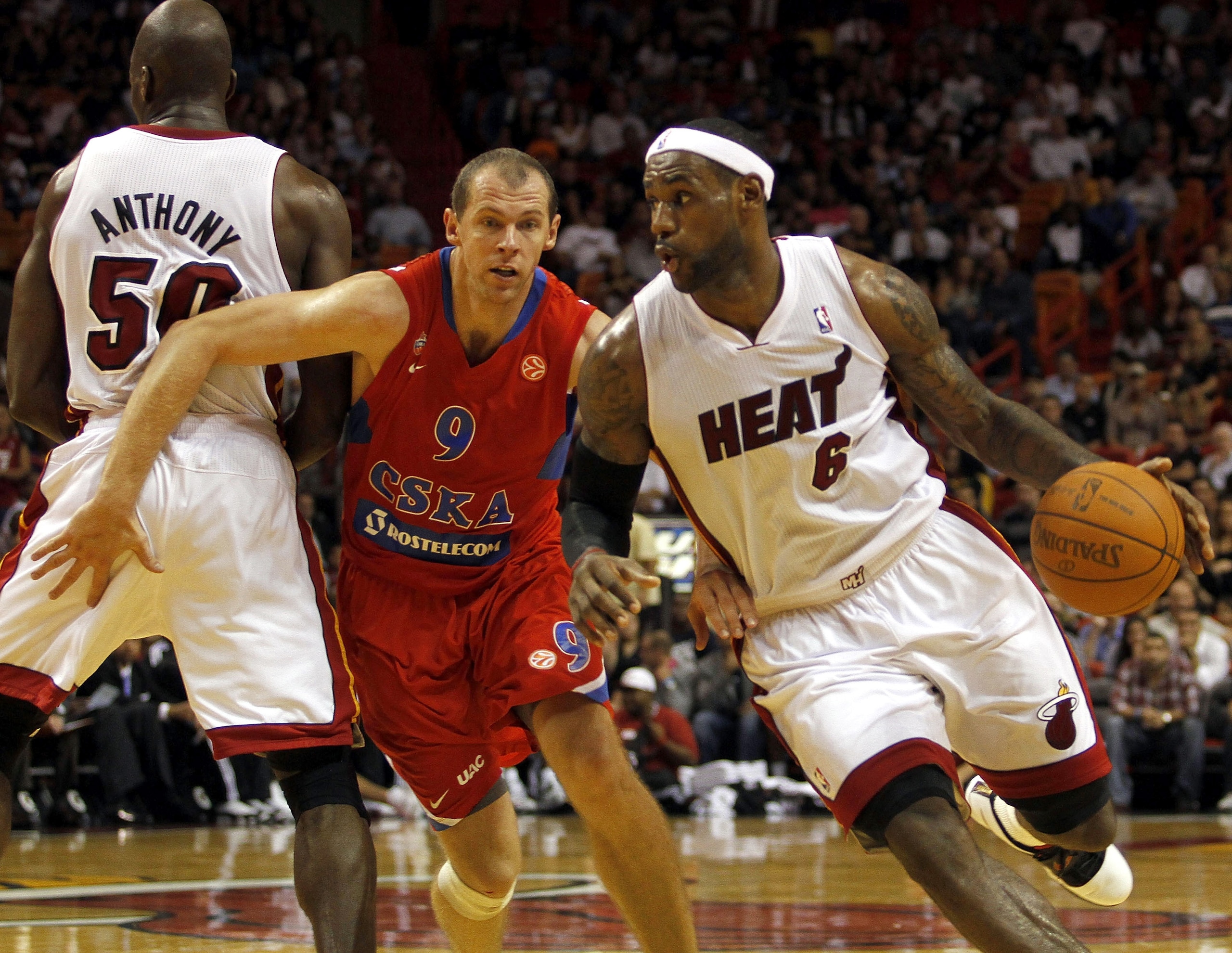 MIAMI - OCTOBER 12:  Forward LeBron James #6 of the Miami Heat drives around forward Ramunas Siskauskas #9 of CSKA Moscow as teammate Joel Anthony #50 sets a screen on October 12, 2010 in Miami, Florida.  Miami heat won 96-85 over CSKA Moscow.  NOTE TO US