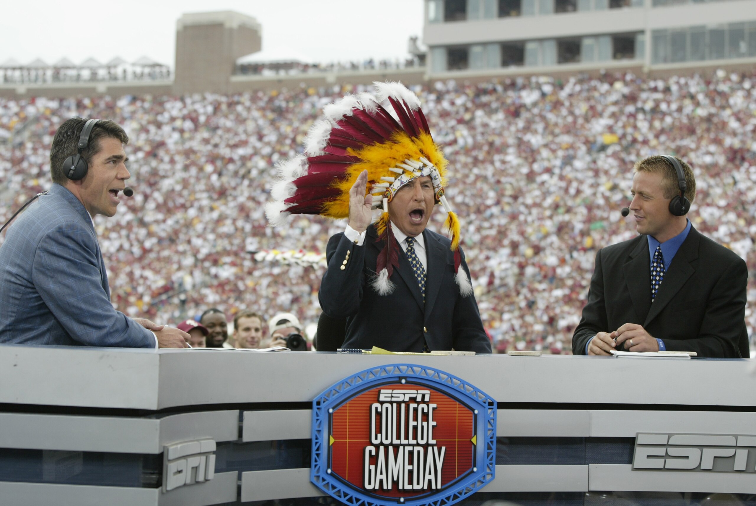 TALLAHASSEE, FL - OCTOBER 26:  ESPN College GameDay announcer Lee Corso dons an FSU headress as co-announcers (l to r) Chris Fowler and Kirk Herbstreit comment during the NCAA football game between Notre Dame and Florida State at Doak Campbell Stadium on 