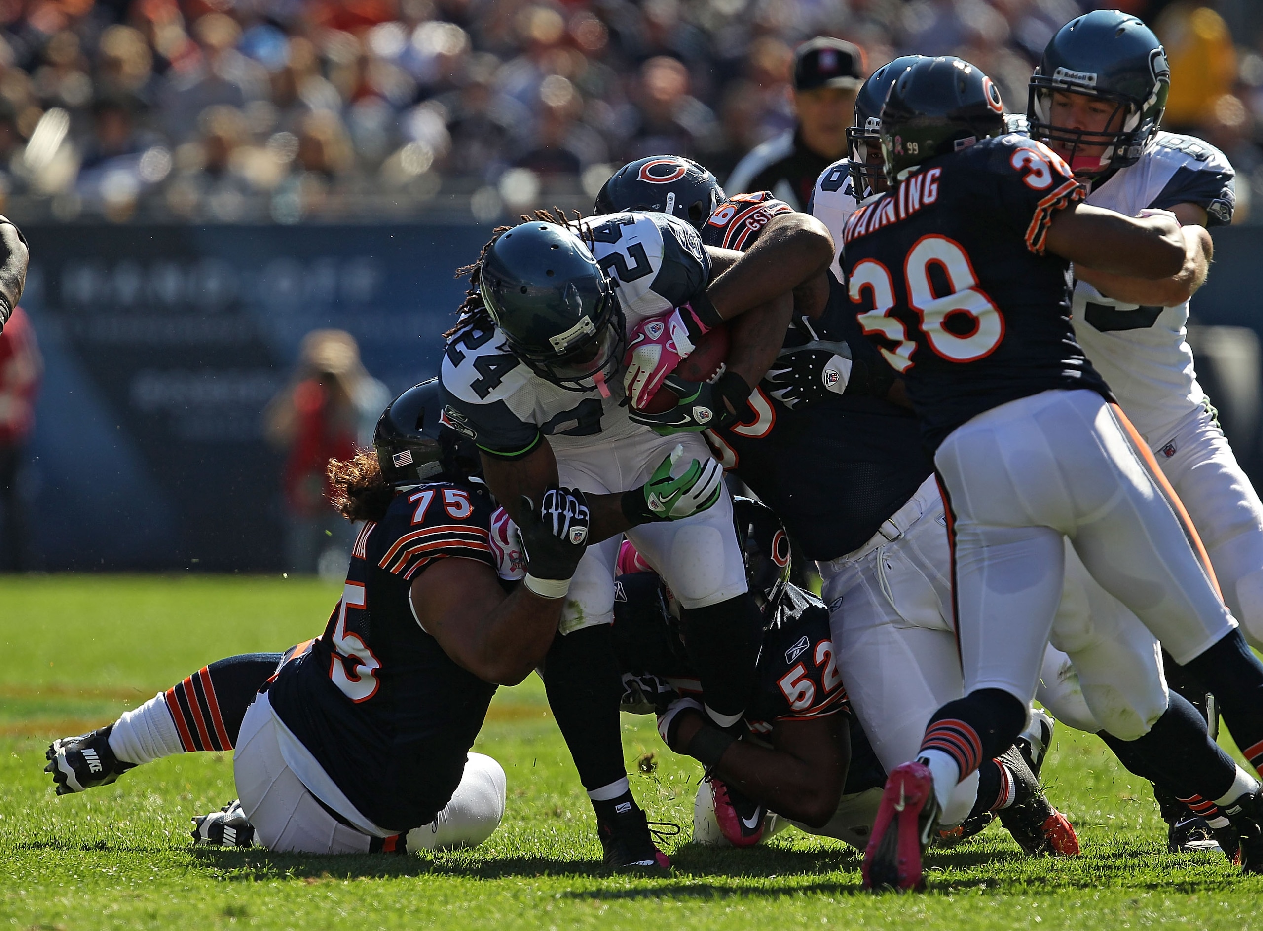 CHICAGO - OCTOBER 17: Marshawn Lynch #24 of the Seattle Seahawks is stopped by Matt Toeaina #75 (L) and Henry Melton #69 of the Chicago Bears at Soldier Field on October 17, 2010 in Chicago, Illinois. The Seahawks defeated the Bears 23-20.  (Photo by Jona