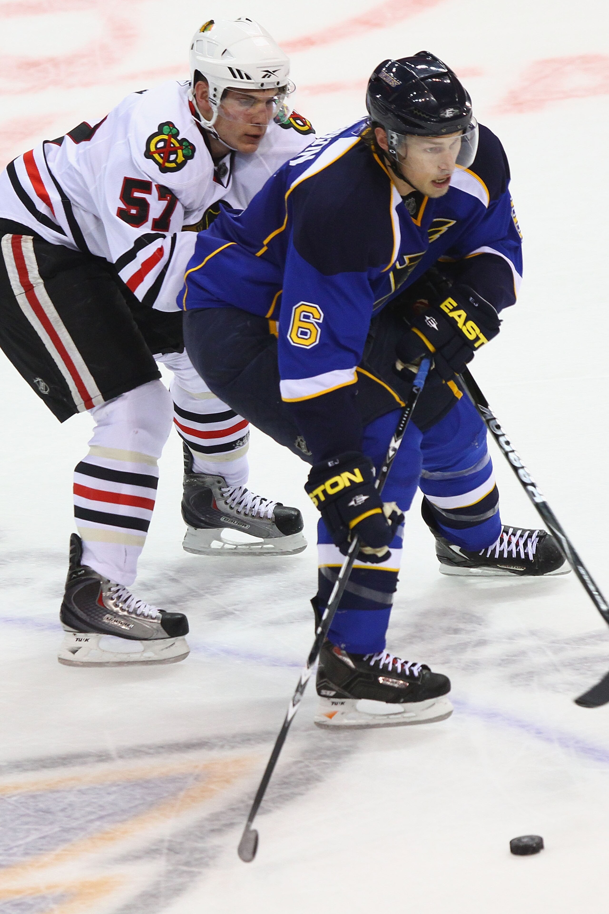 ST. LOUIS - SEPTEMBER 30: Erik Johnson #6 of the St. Louis Blues controls the puck against Ben Smith #57 of the Chicago Blackhawks during a pre-season game at the Scottrade Center on September 30, 2010 in St. Louis, Missouri.  (Photo by Dilip Vishwanat/Ge