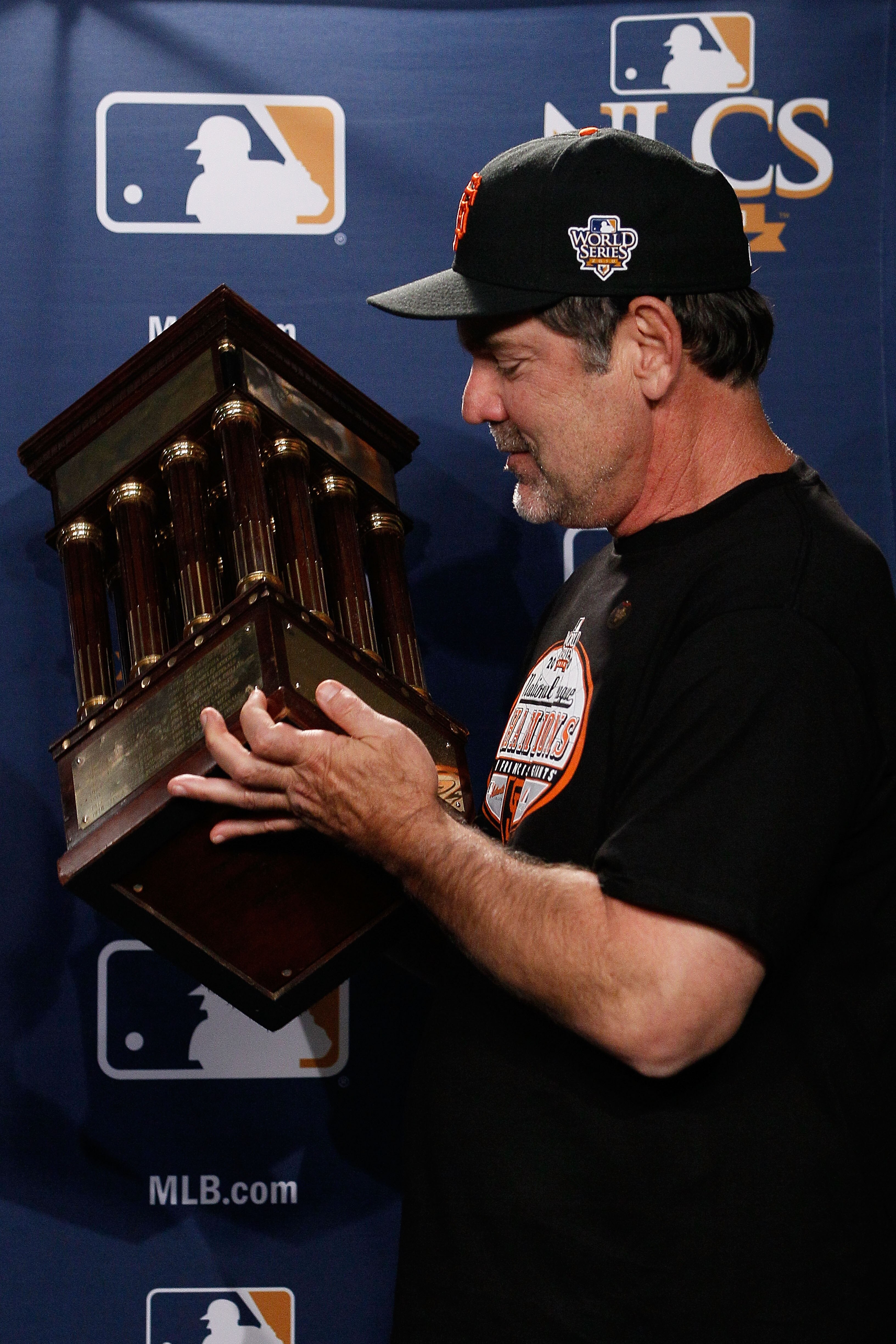 PHILADELPHIA - OCTOBER 23:  Manager Bruce Bochy of the San Francisco Giants celebrates with the trophy after defeating the Philadelphia Phillies 3-2 and winning the pennant in Game Six of the NLCS during the 2010 MLB Playoffs at Citizens Bank Park on Octo