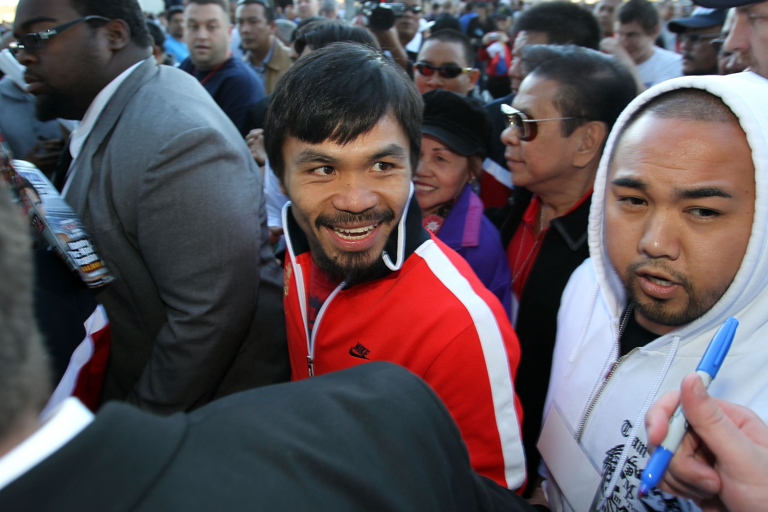 ARLINGTON, TX - MARCH 12:  (C) Manny Pacquiao of the Philippines smiles as he leaves the stage after his weigh-in for his WBO welterweight title fight against Joshua Clottey of Ghana outside Cowboys Stadium on March 12, 2010 in Arlington, Texas. Pacquiao