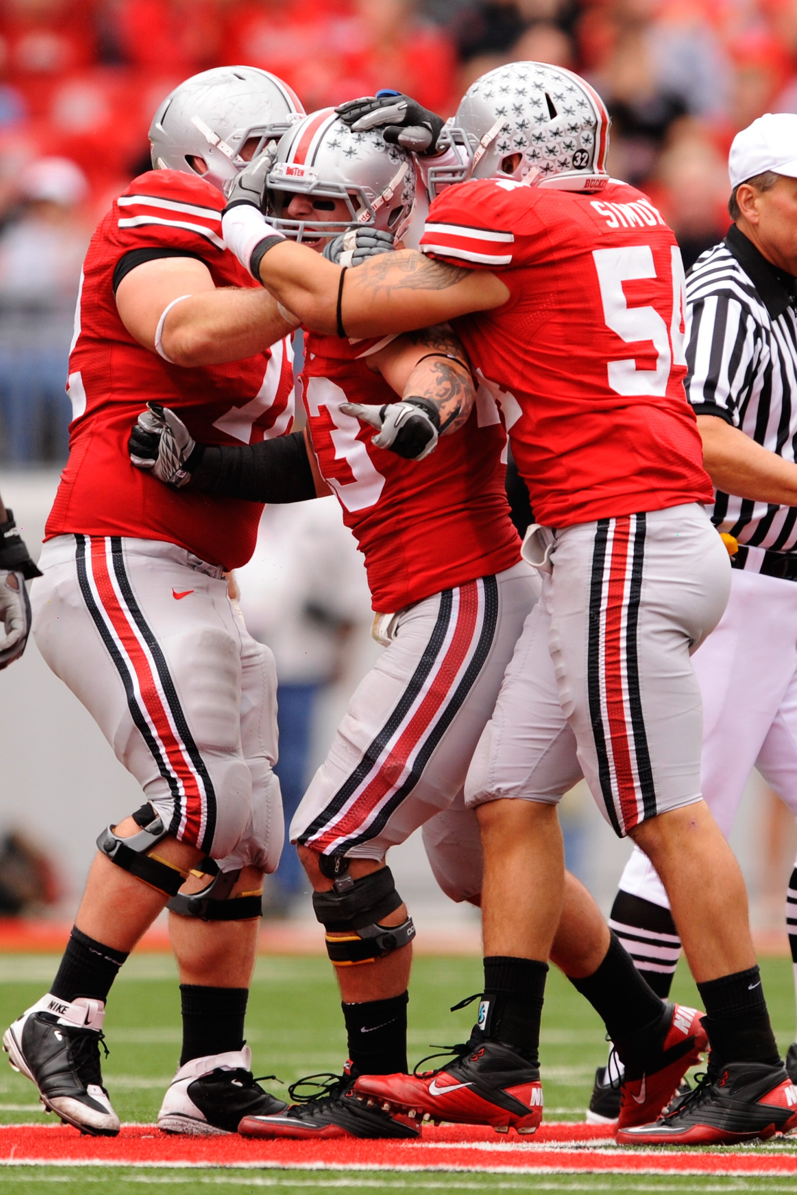 COLUMBUS, OH - OCTOBER 23:  Nathan Williams #43 of the Ohio State Buckeyes celebrates with Dexter Larimore #72 of the Ohio State Buckeyes and John Simon #54 of the Ohio State Buckeyes after making a tackle on fourth down against the Purdue Boilermakers at