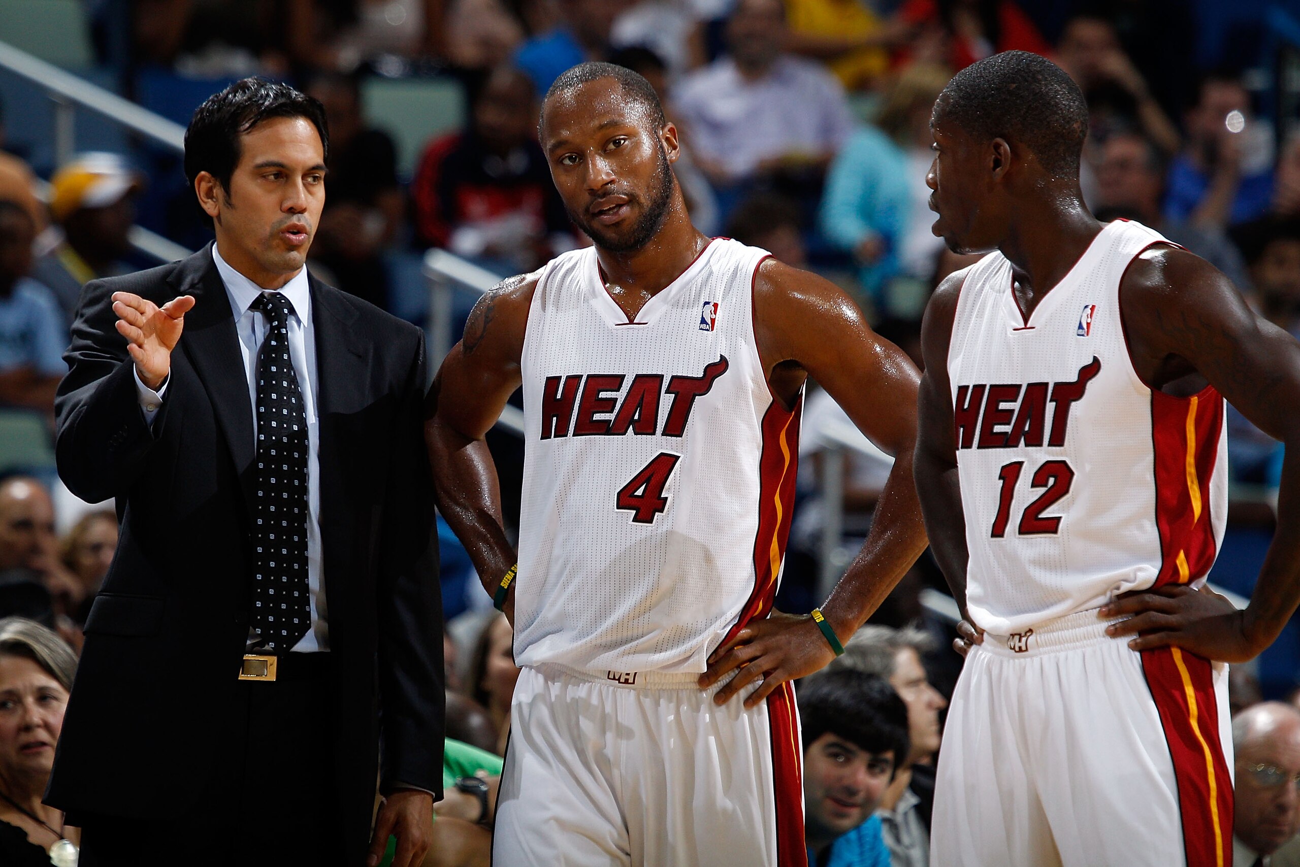 NEW ORLEANS - OCTOBER 13:  Head coach Erik Spoelstra talks with Kenny Hasbrouck #4 and Patrick Beverley #12 of the Miami Heat sit on the bench during the game against the New Orleans Hornets at the New Orleans Arena on October 13, 2010 in New Orleans, Lou