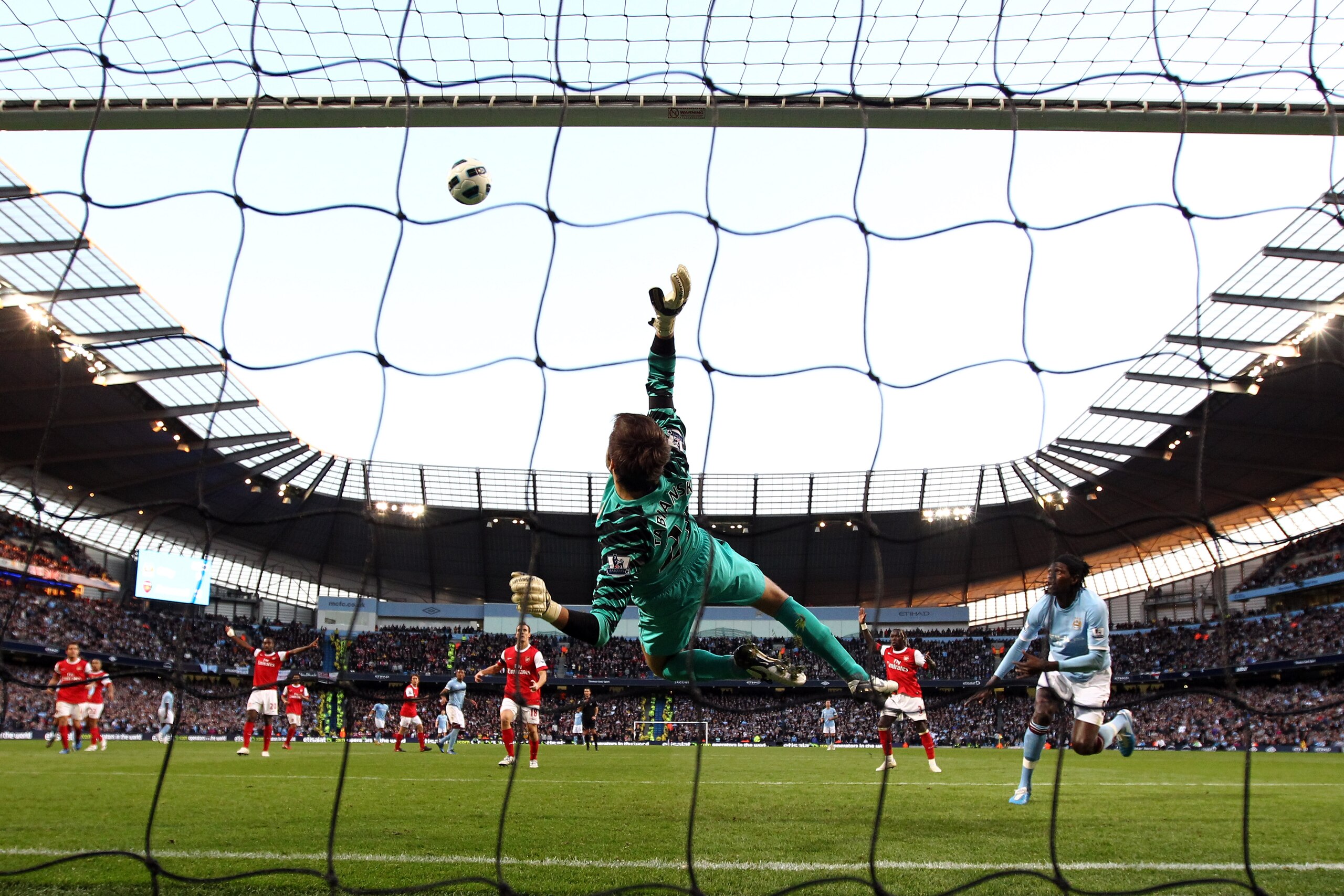 MANCHESTER, ENGLAND - OCTOBER 24: Lukasz Fabianski of Arsenal makes a save from Emmanuel Adebayor of Manchester City during the Barclays Premier League match between Manchester City and Arsenal at City of Manchester Stadium on October 24, 2010 in Manchest