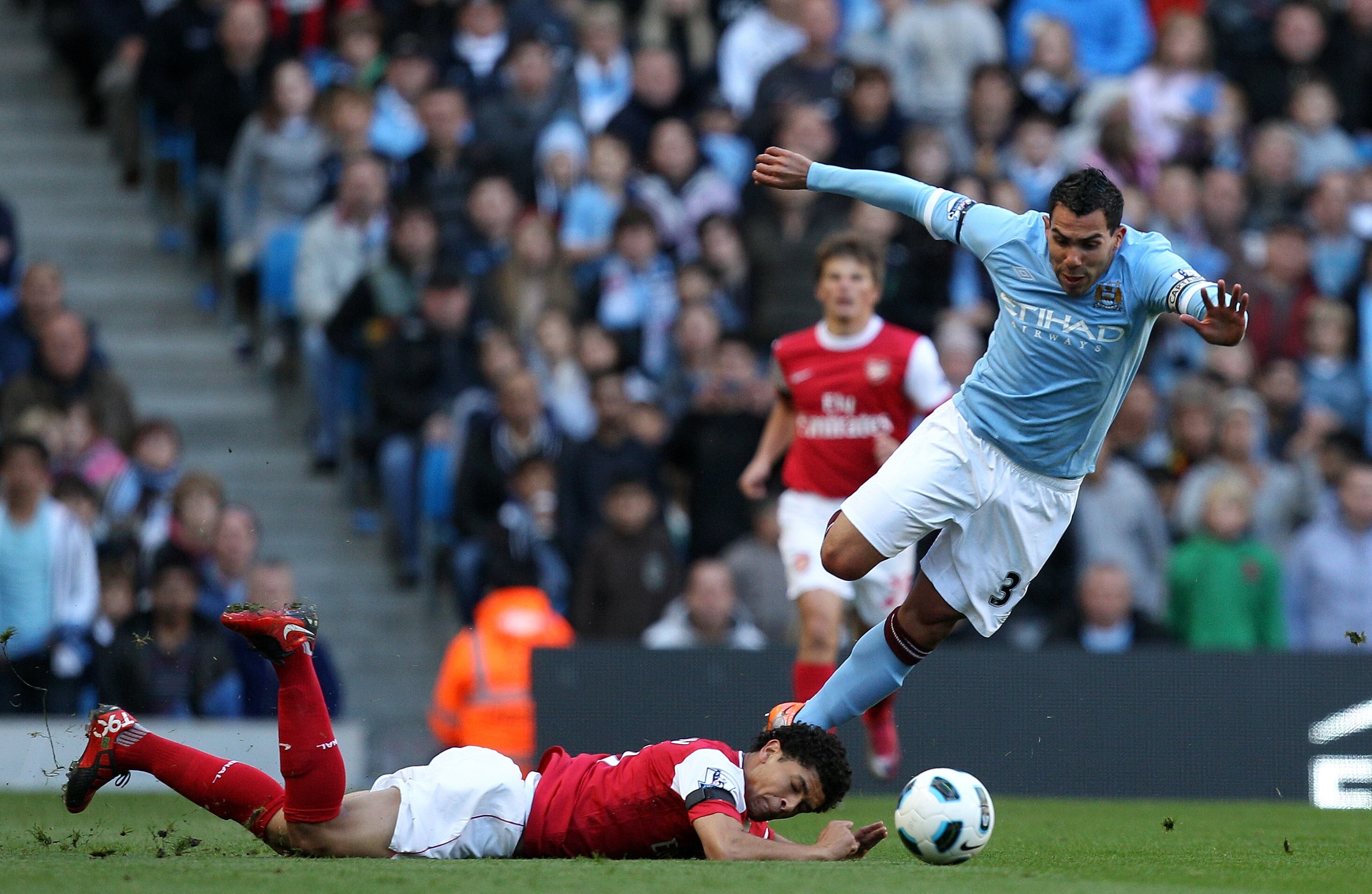 MANCHESTER, ENGLAND - OCTOBER 24:  Carlos Tevez of City is brought down by Denilson of Arsenal during the Barclays Premier League match between Manchester City and Arsenal at City of Manchester Stadium on October 24, 2010 in Manchester, England.  (Photo b