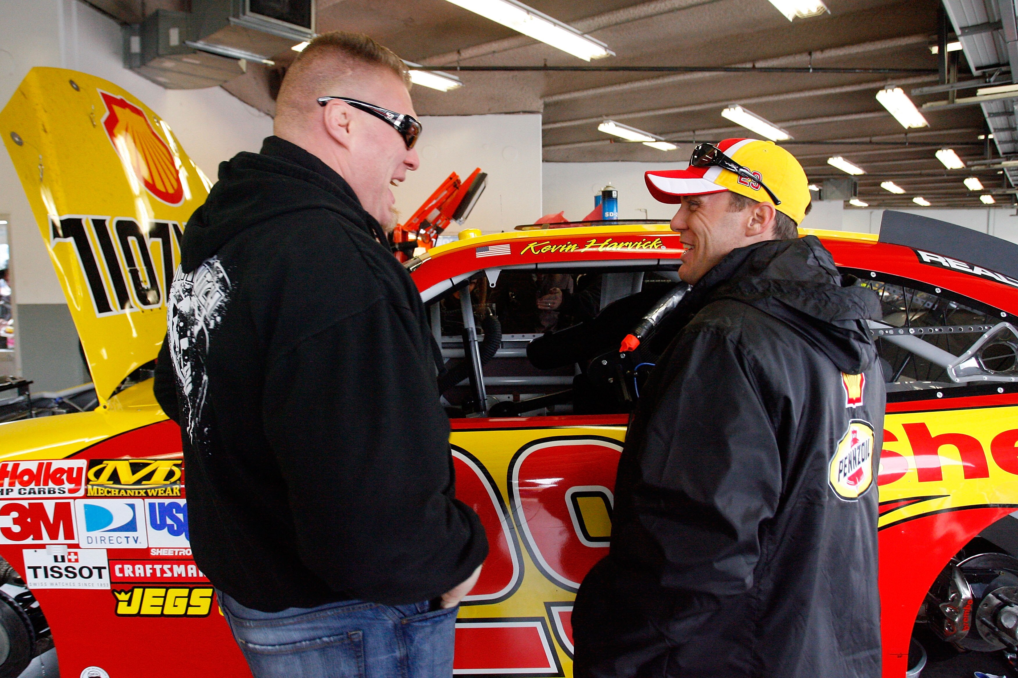 DAYTONA BEACH, FL - FEBRUARY 13:  MMA fighter Brock Lesnar speaks with Kevin Harvick, driver of the #29 Shell/Pennzoil Chevrolet, during practice for the Daytona 500 at Daytona International Speedway on February 13, 2010 in Daytona Beach, Florida.  (Photo