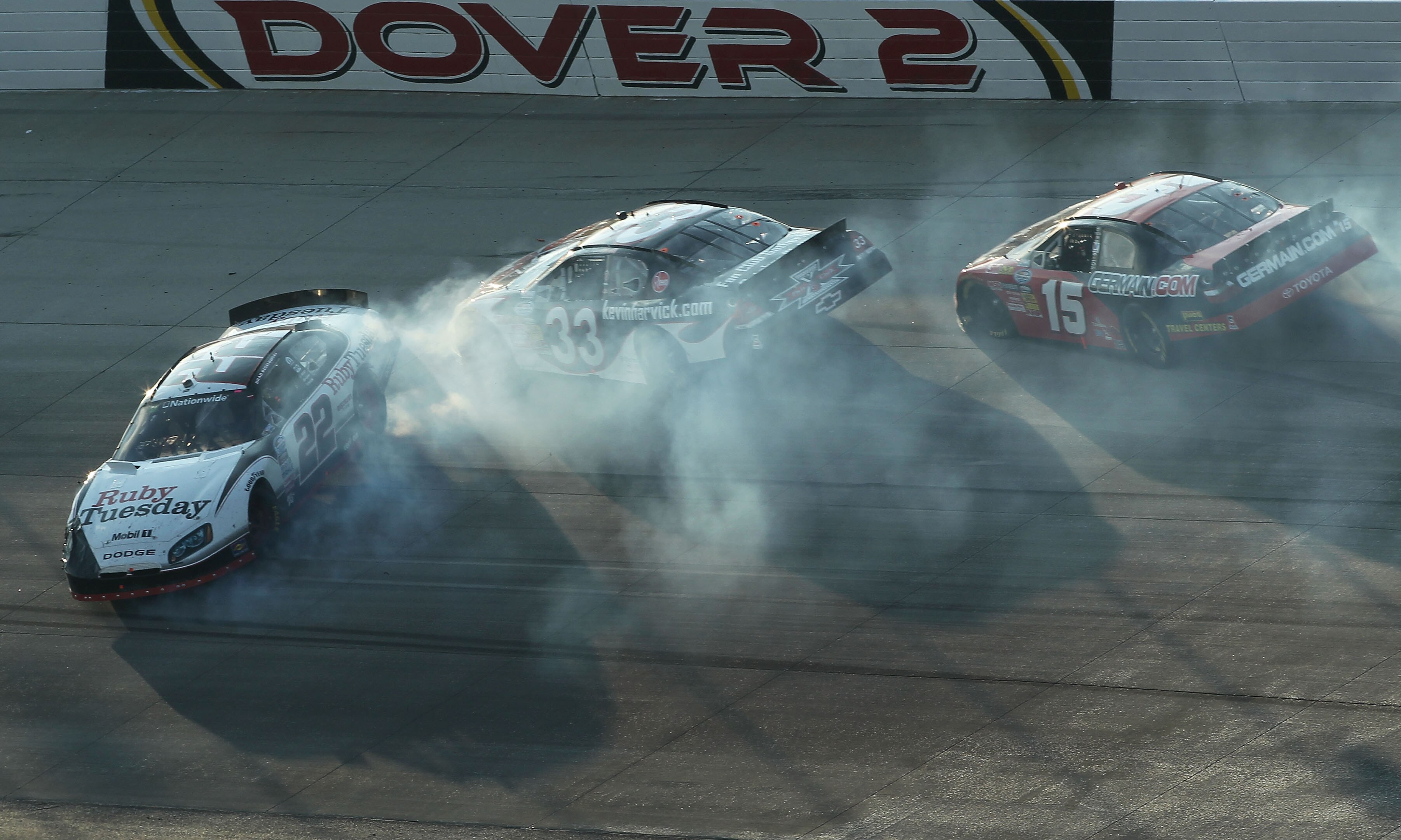 DOVER, DE - SEPTEMBER 25:  Brad Keselowski, driver of the #22 Ruby Tuesday/Discount Tire Dodge, crashes with Kevin Harvick, driver of the #33 Kevin Harvicks Fan Club Chevrolet, and Michael Annett, driver of the #15 Germain.com Toyota, during the NASCAR Na