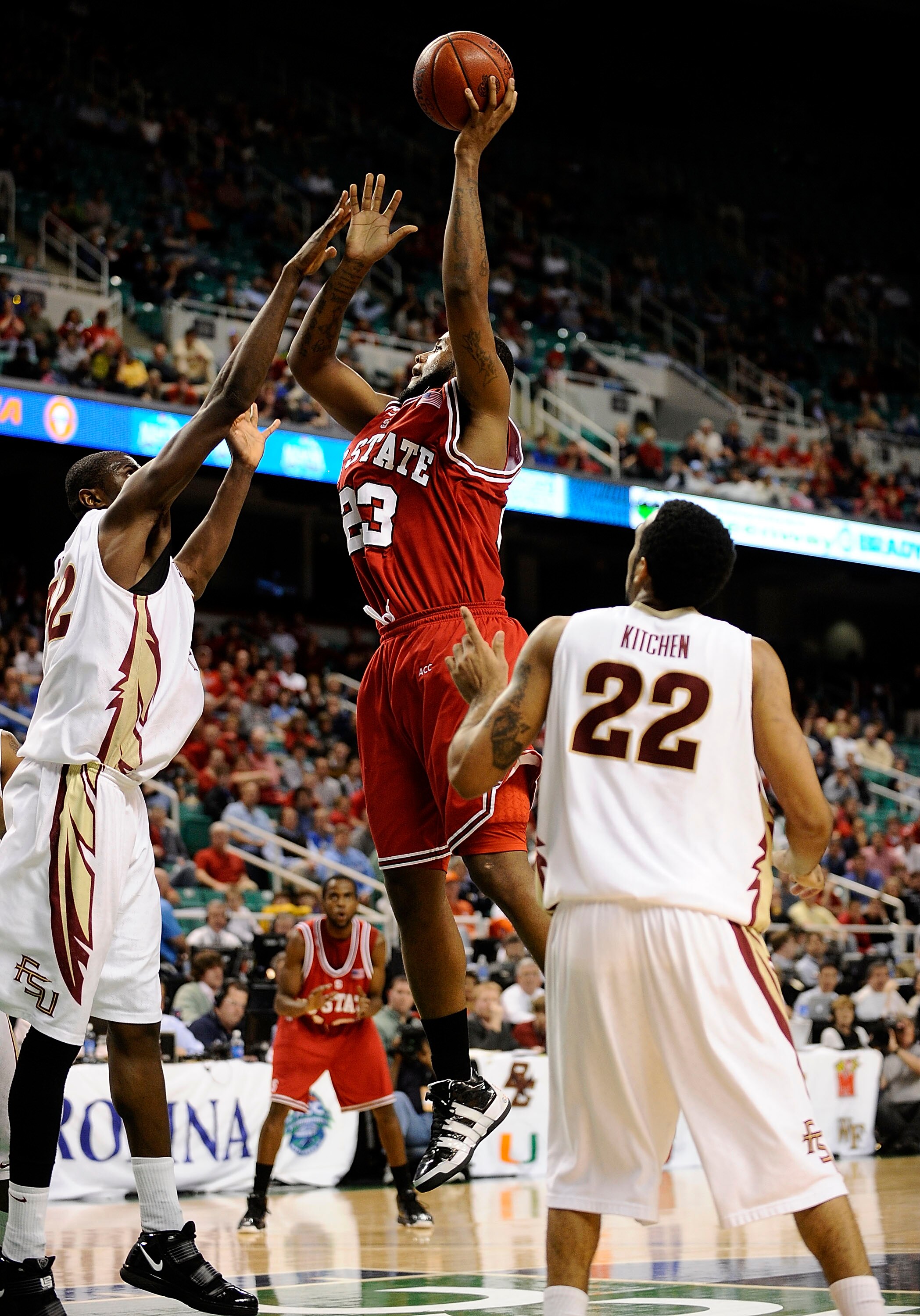 GREENSBORO, NC - MARCH 12:  Tracy Smith #23 of the North Carolina State Wolfpack shoots between Solomon Alabi #32 and Derwin Kitchen #22 of the Florida State Seminoles in their quarterfinal game in the 2010 ACC Men's Basketball Tournament at the Greensbor