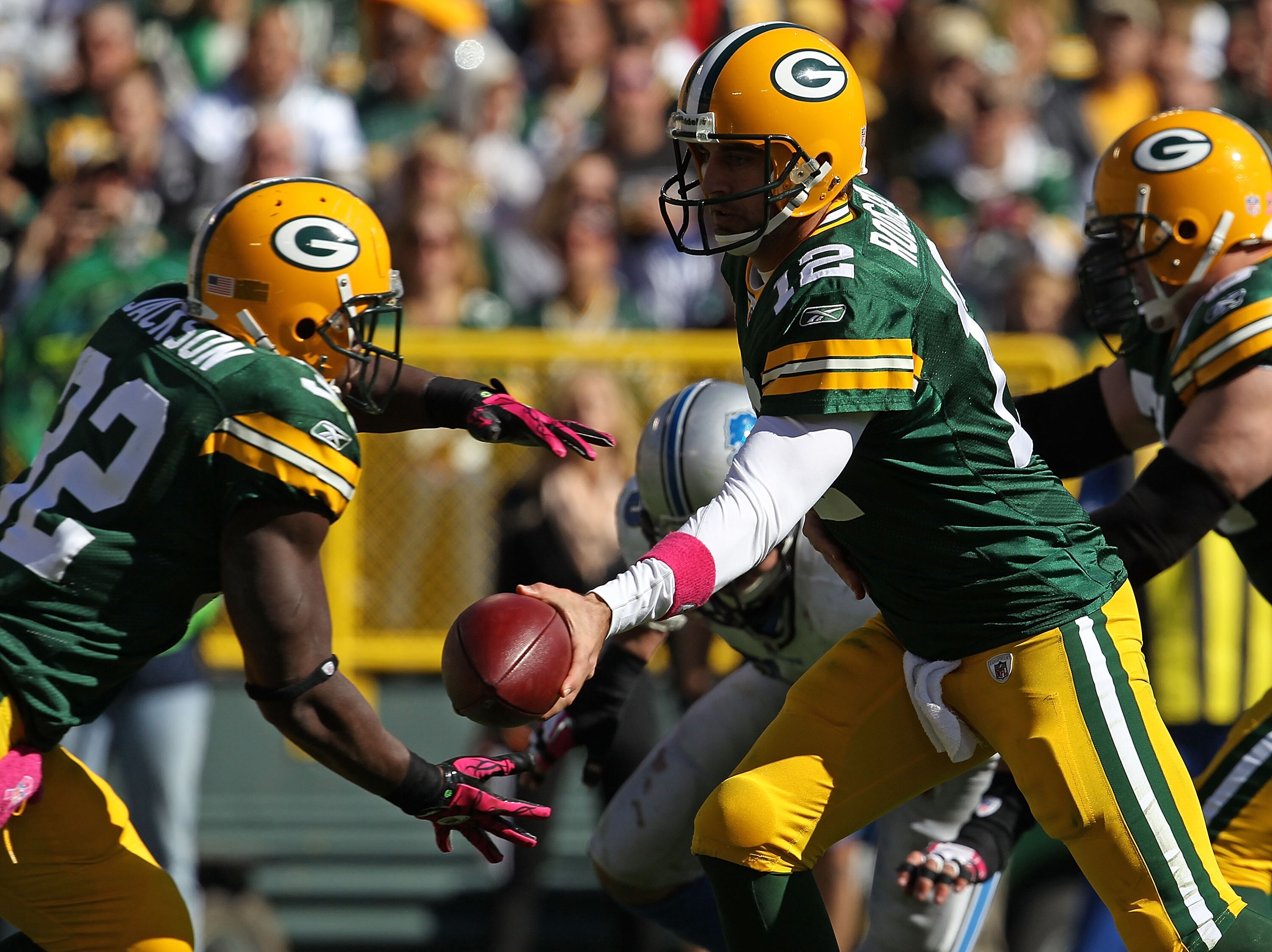 GREEN BAY, WI - OCTOBER 03: Aaron Rodgers #12 of the Green Bay Packers hands off to Brandon Jackson #32 against the Detroit Lions at Lambeau Field on October 3, 2010 in Green Bay, Wisconsin. The Packers defeated the Lions 28-26. (Photo by Jonathan Daniel/