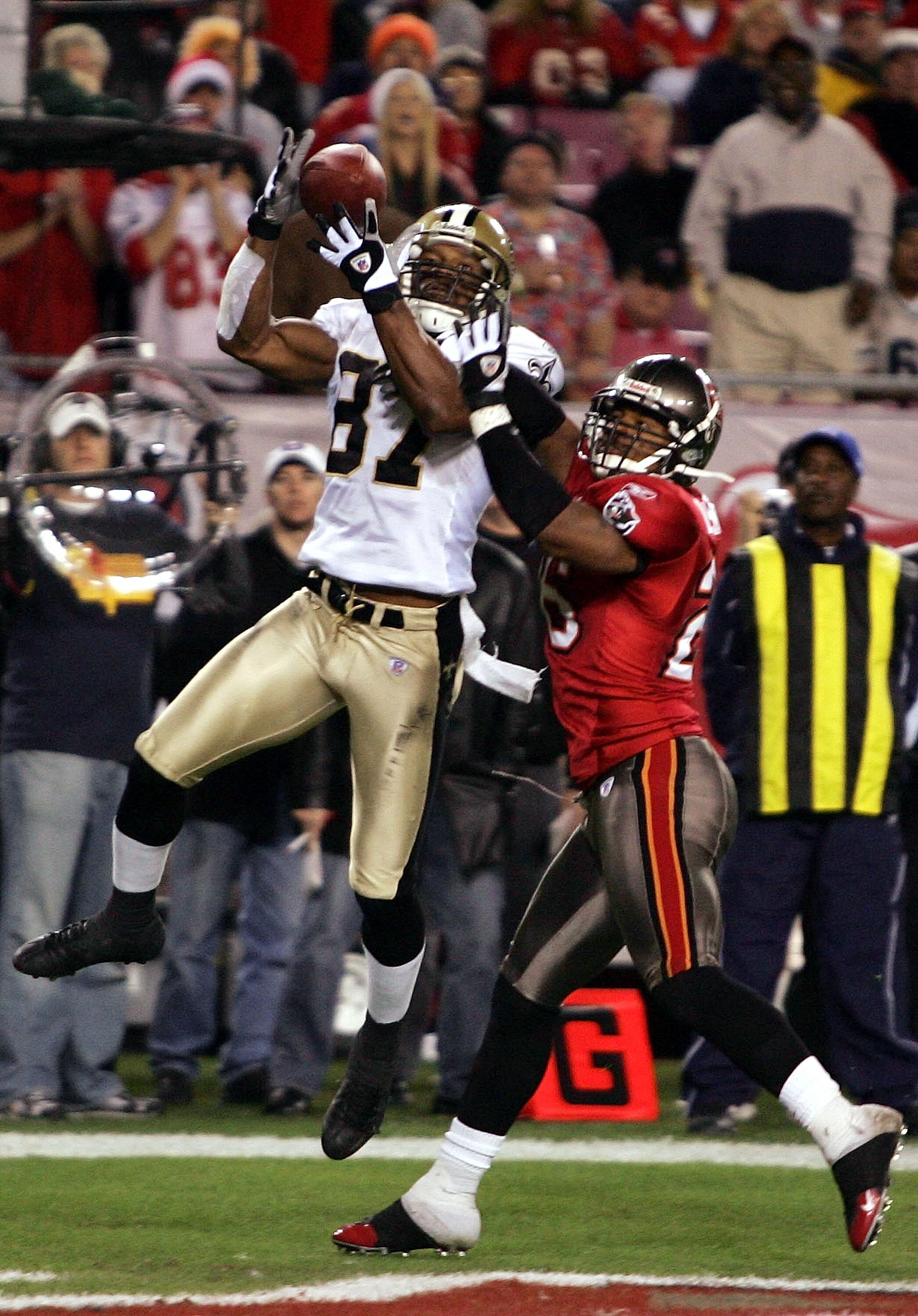 TAMPA - DECEMBER 19:  Joe Horn #83 of the New Orleans Saints makes a catch for a touchdown over Dwight Smith #26 of the Tampa Bay Buccaneers to trail 14-17 during the fourth quarter on December 19, 2004 at Raymond James Stadium in Tampa, Florida.  (Photo