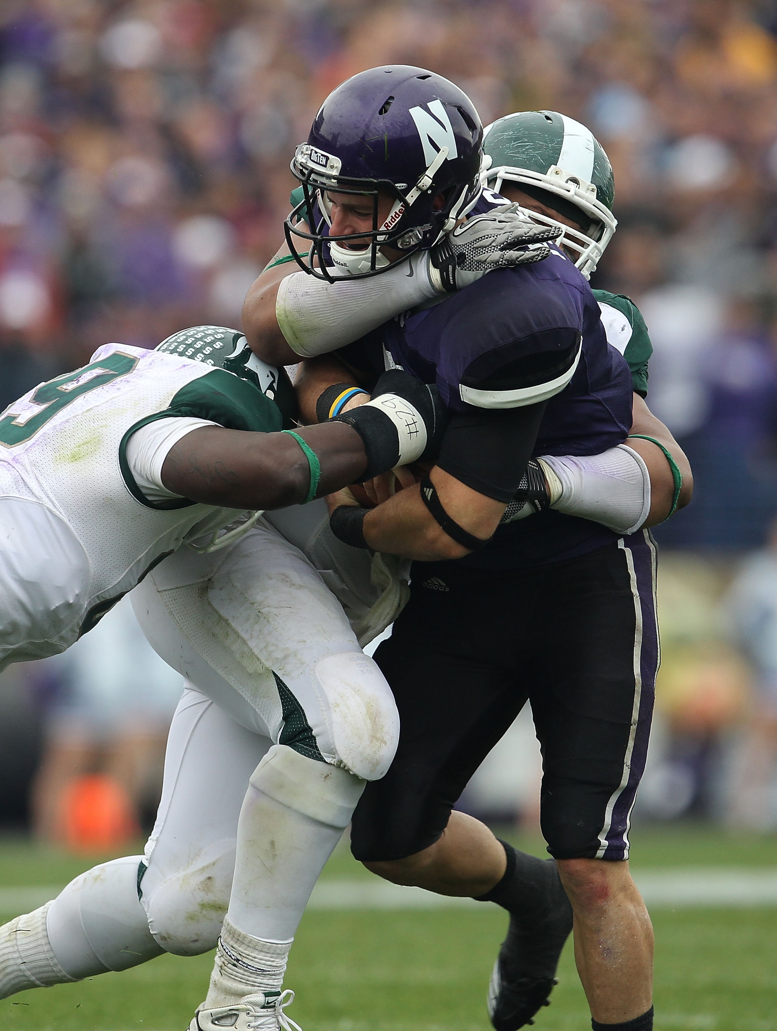 EVANSTON, IL - OCTOBER 23: Dan Persa #7 of the Northwestern Wildcats is stopped by Colin Neely #89 and Jerel Worthy #99 of the Michigan State Spartans at Ryan Field on October 23, 2010 in Evanston, Illinois. Michigan State defated Northwestern 35-27. (Pho